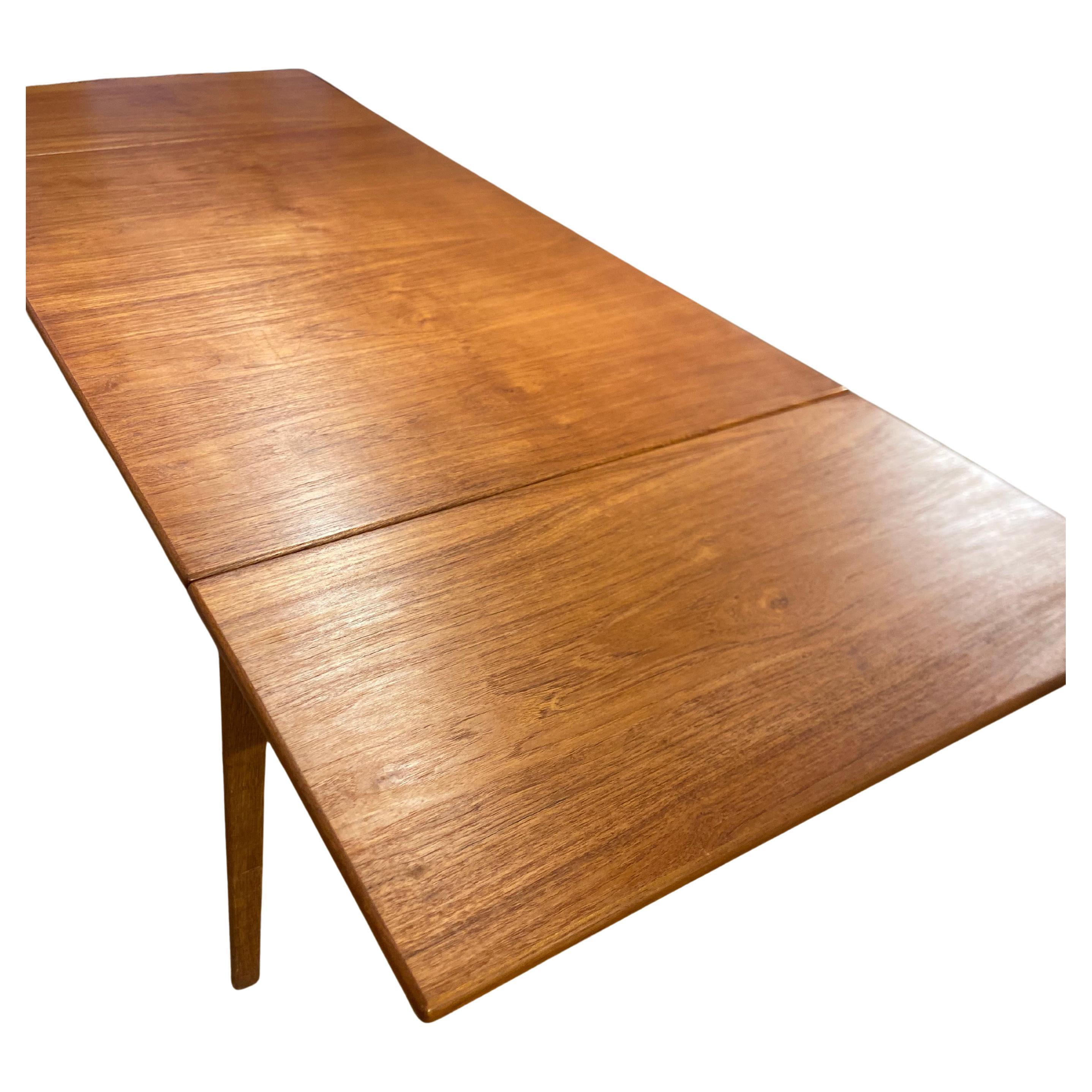Très belle table en teck avec pieds en chêne modèle 162 conçue en 1953 par Borge Mogensen, tout à fait dans son style simple, fonctionnel et élégant. Le plateau est en teck, les pieds en chêne et il y a un très beau système d'attaches en métal