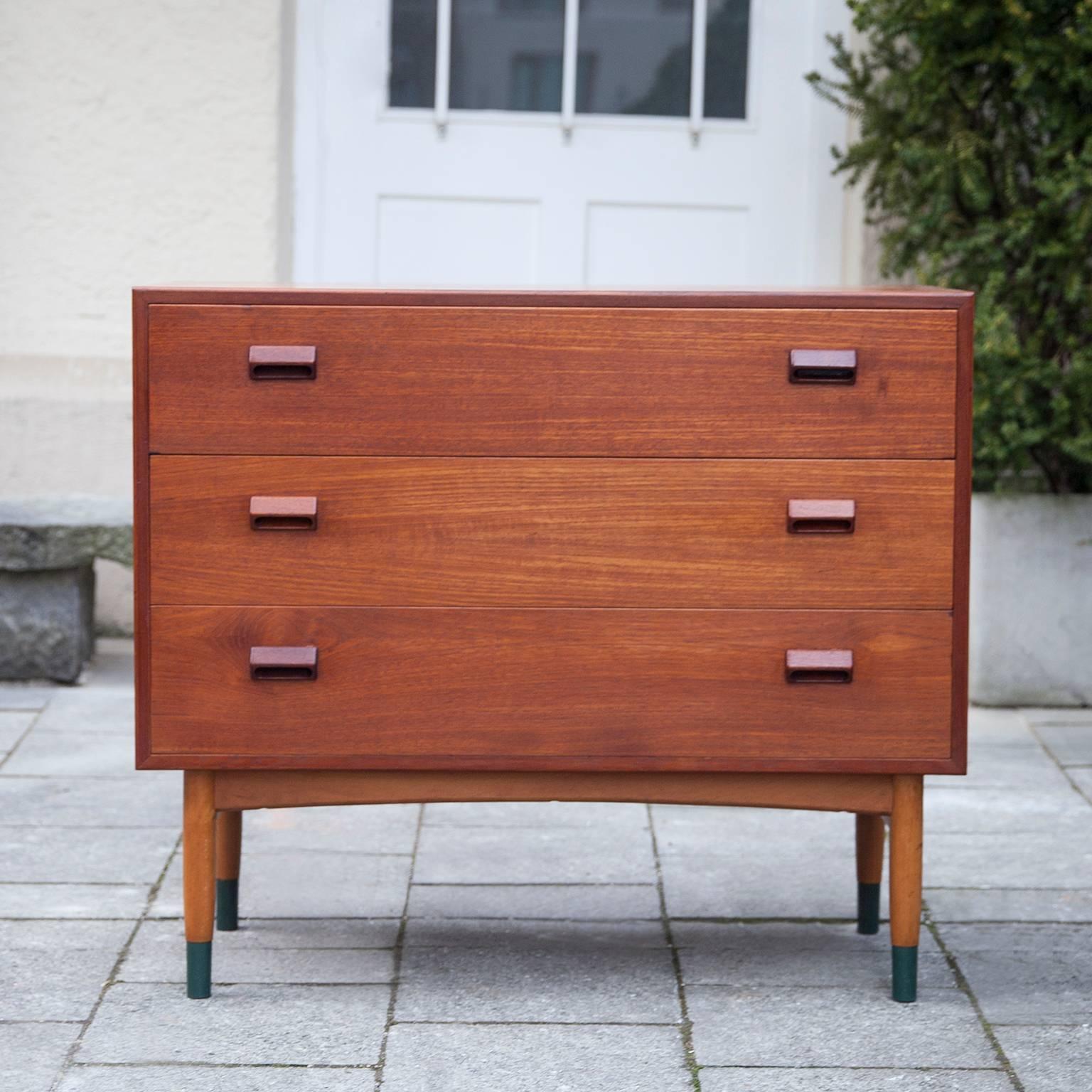 Børge Mogensen designed this vanity dresser or small desk for Søborg Møbelfabrik in 1951. The case is crafted in teak and stands on an oak base with brass ends. Each drawer is adorned with the designer’s signature handle and under the first drawer