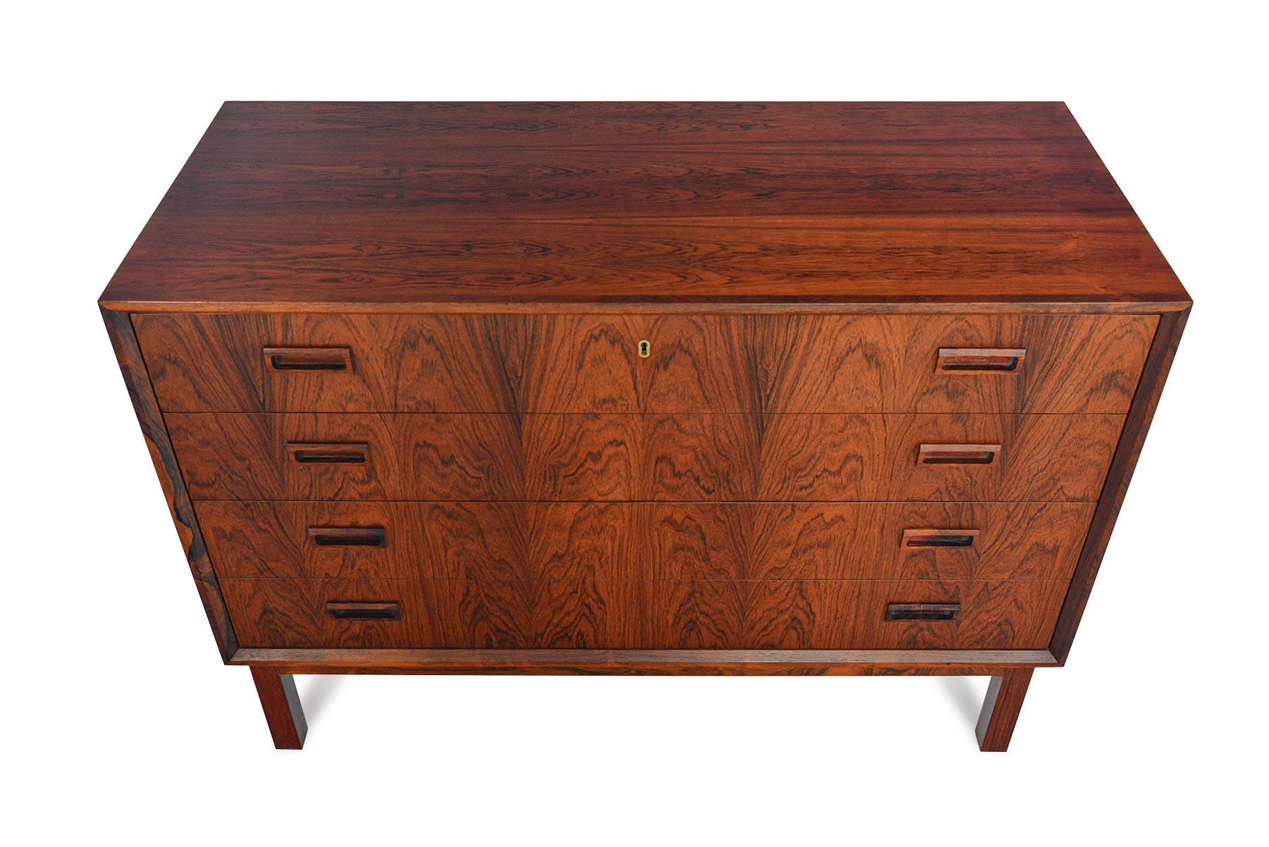 This jaw-dropping Danish modern midcentury gentleman’s chest features four extra wide drawers accented by hand carved rectangular drawer pulls. Designed by Borge Seindal, this stunning piece is finished in Brazilian rosewood. Chest features