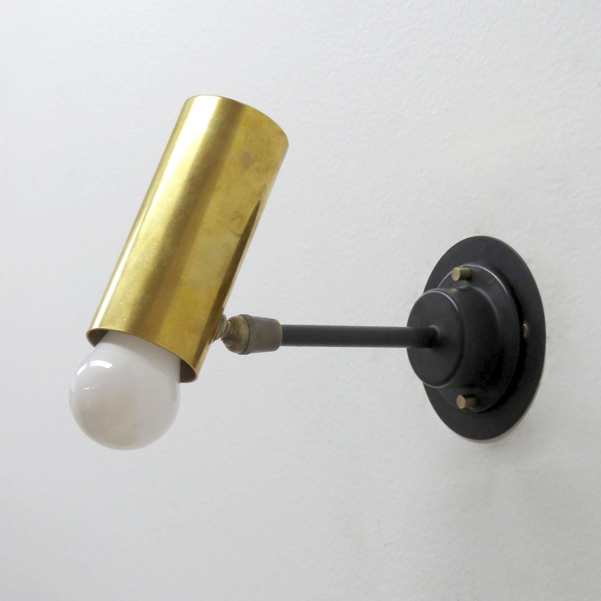 Elegant articulate wall lights, in brass and black enameled metal, swivel joint at the cylinder, complementary detachable shade extensions in black (not shown) & custom US back plate. Wired for US standards, one E27 socket per fixture, max. wattage