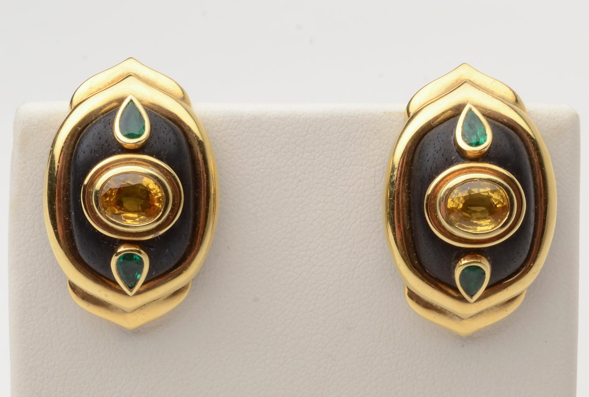 Sporty and unusual earrings by Boris Le Beau who sold jewelry from his shop on Madison Avenue for 40 years. A central yellow sapphire has pear shaped emeralds above and below. All are set in 18 karat gold on ebony.
Omega backs.