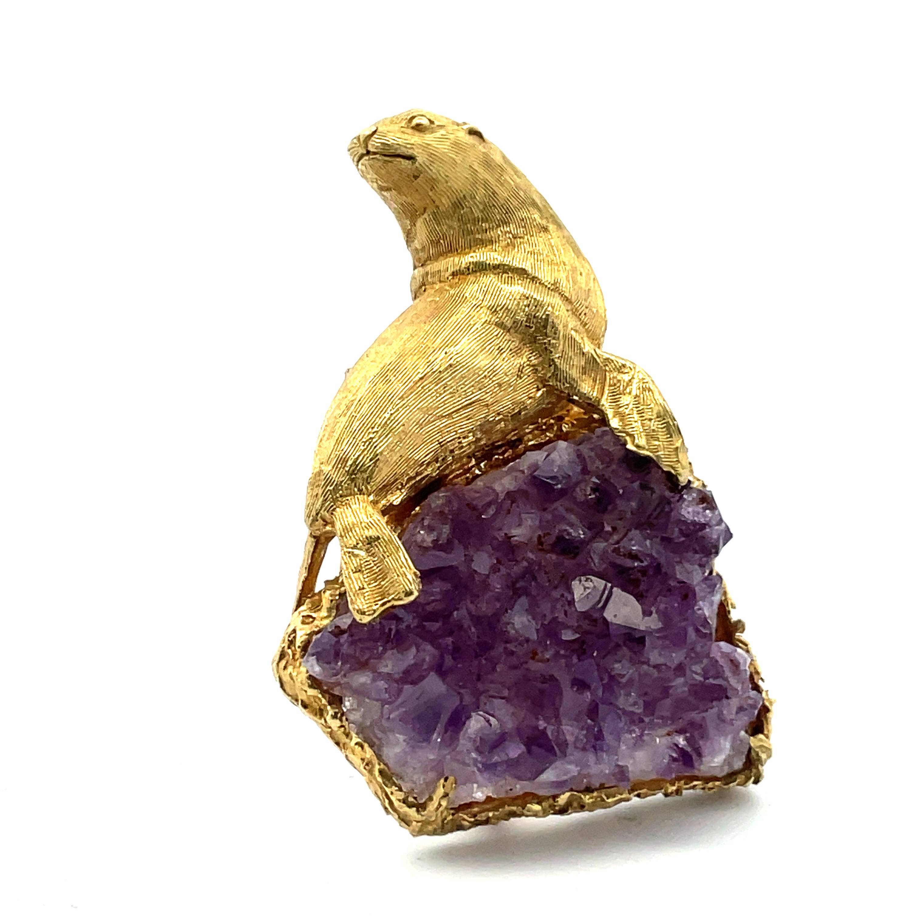 The bold design of the 1970's is manifest in Boris LeBeau's 18K gold brooch with sculpted seal perched on an amethyst drusy crystal.  The brooch measures 1-1/2