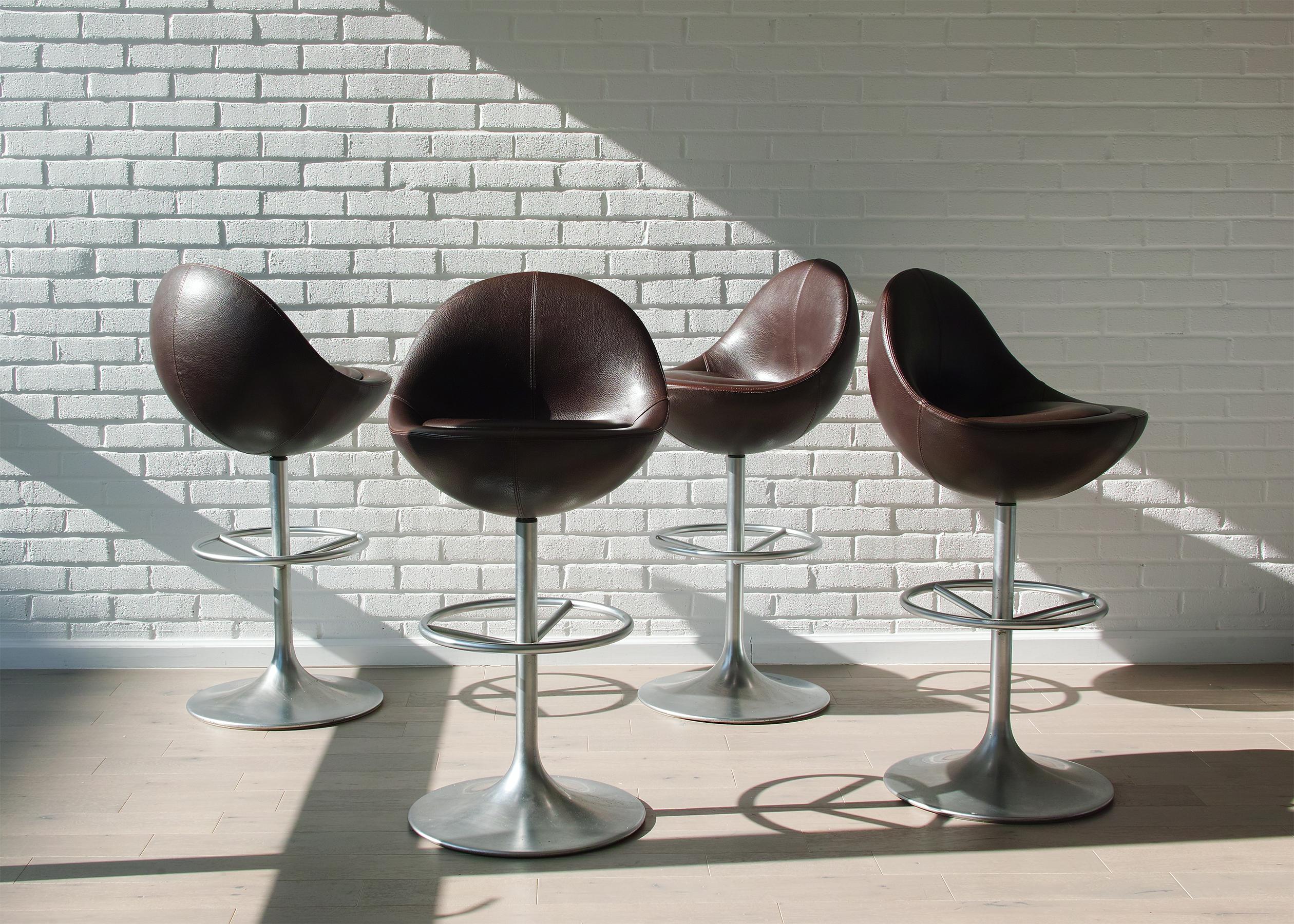 For your consideration is this Scandinavian modern set of four bar height swivel stools by Börje Johanson in very good, all original condition. They feature the original, durable dark brown leatherette upholstery over a comfortable, distinctive egg