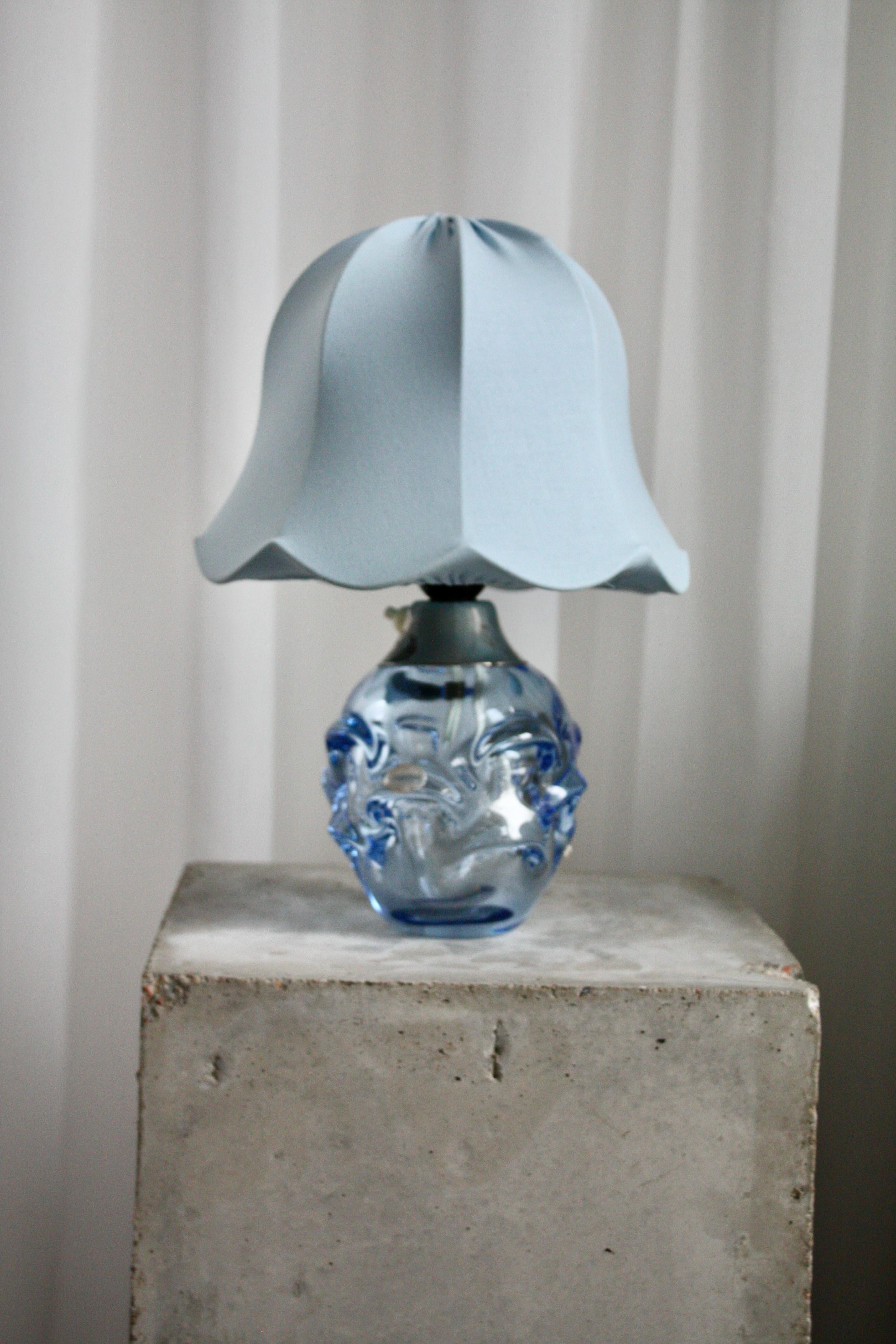 Lampe de table raffinée et sculpturale conçue par Börne Augustsson pour Åseda Glasbruk, Suède, vers les années 1950. Fabriquée en verre bleu clair légèrement teinté, cette pièce élégante capture l'essence du design scandinave du milieu du siècle