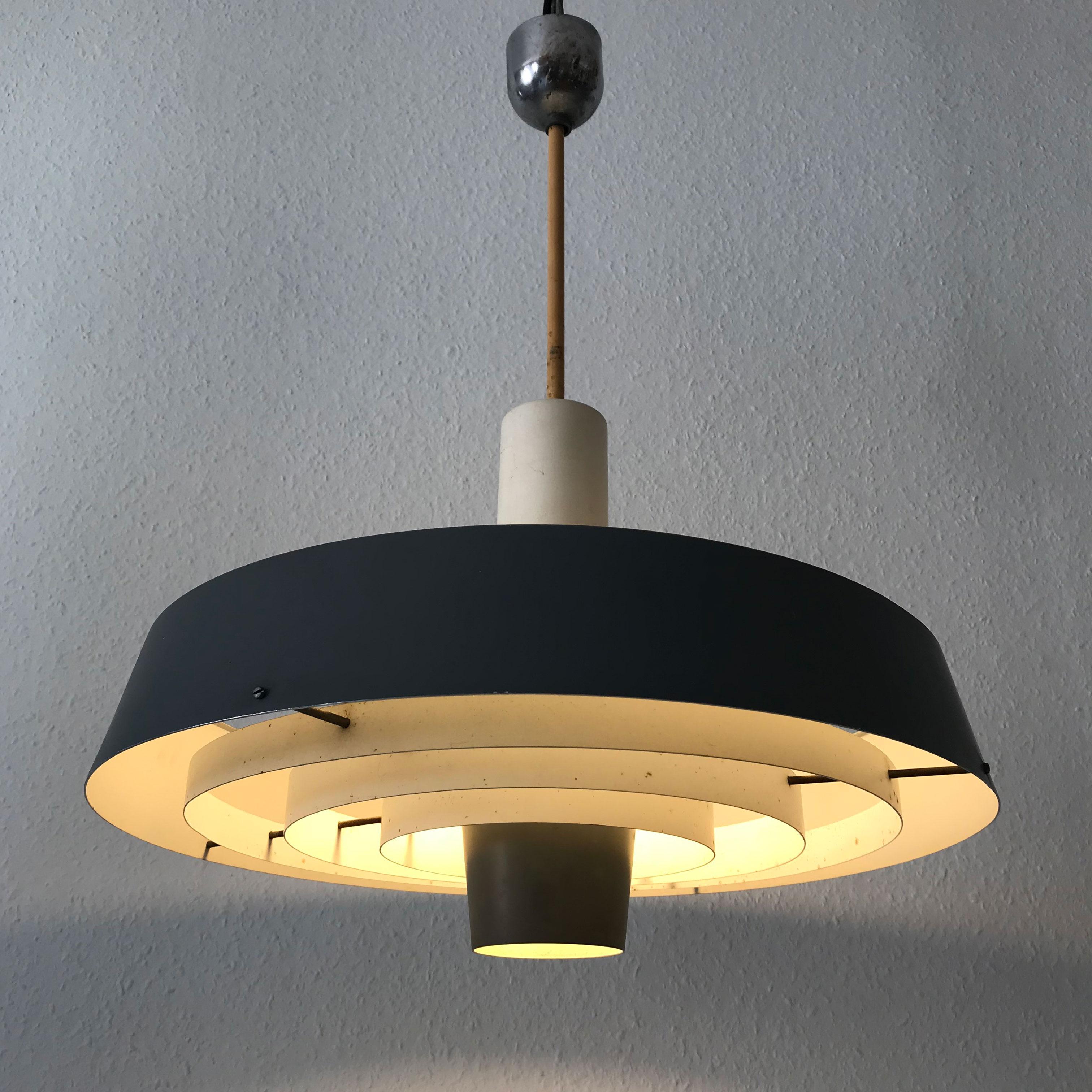 Extremely rare and large Mid-Century Modern Bornholmpendel pendant lamp with several metal rings. Designed by the architects Finn Monies and Gunnar Jensen, 1964 as part of a project creating interior and furniture for Bornholm shipping company.