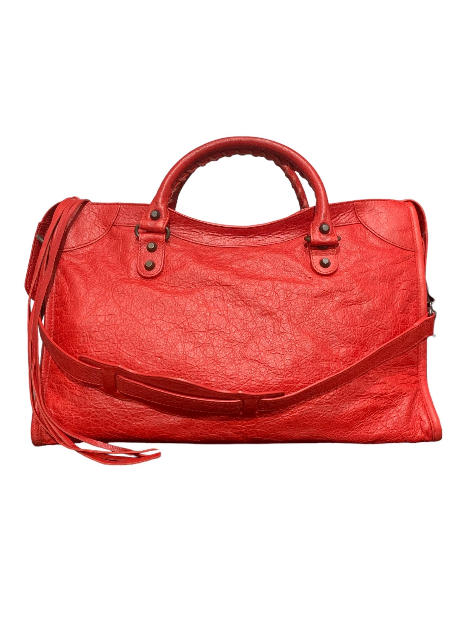 Borsa firmata Balenciaga, modello First Medium, in pelle rossa con hardware nero opaco. Munita di due manici e di una tracolla non regolabile per una portata a mano o a spalla. Dotata di una chiusura con cerniera, internamente rivestita con tessuto