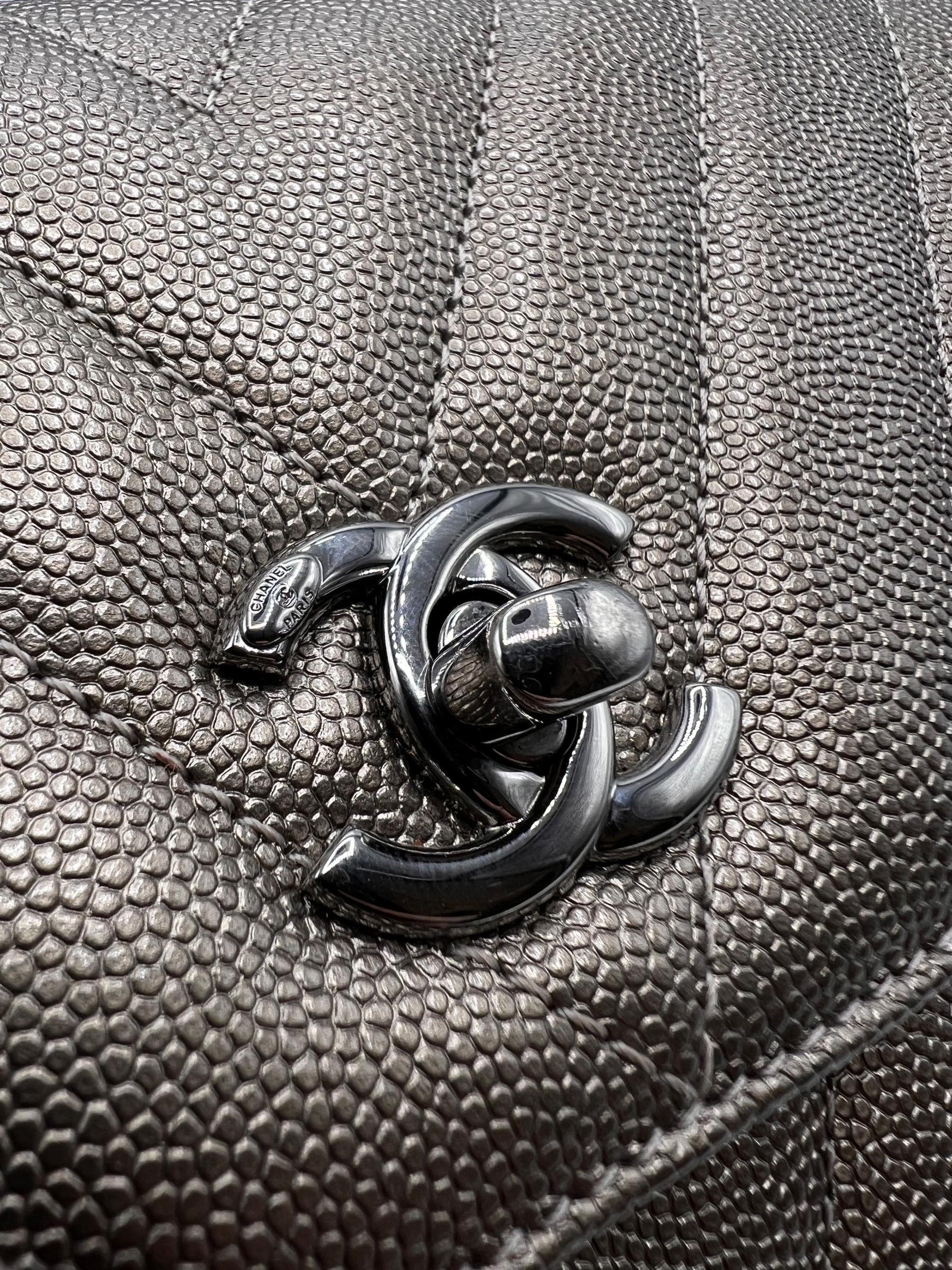 Borsa firmata Chanel, modello Coco Handle, misura mini, realizzata in pelle caviar metallizzata bronzo con hardware in colorazione argento. Dotata di una patta frontale con chiusura a girello e classico logo CC, internamente rivestita in tessuto,