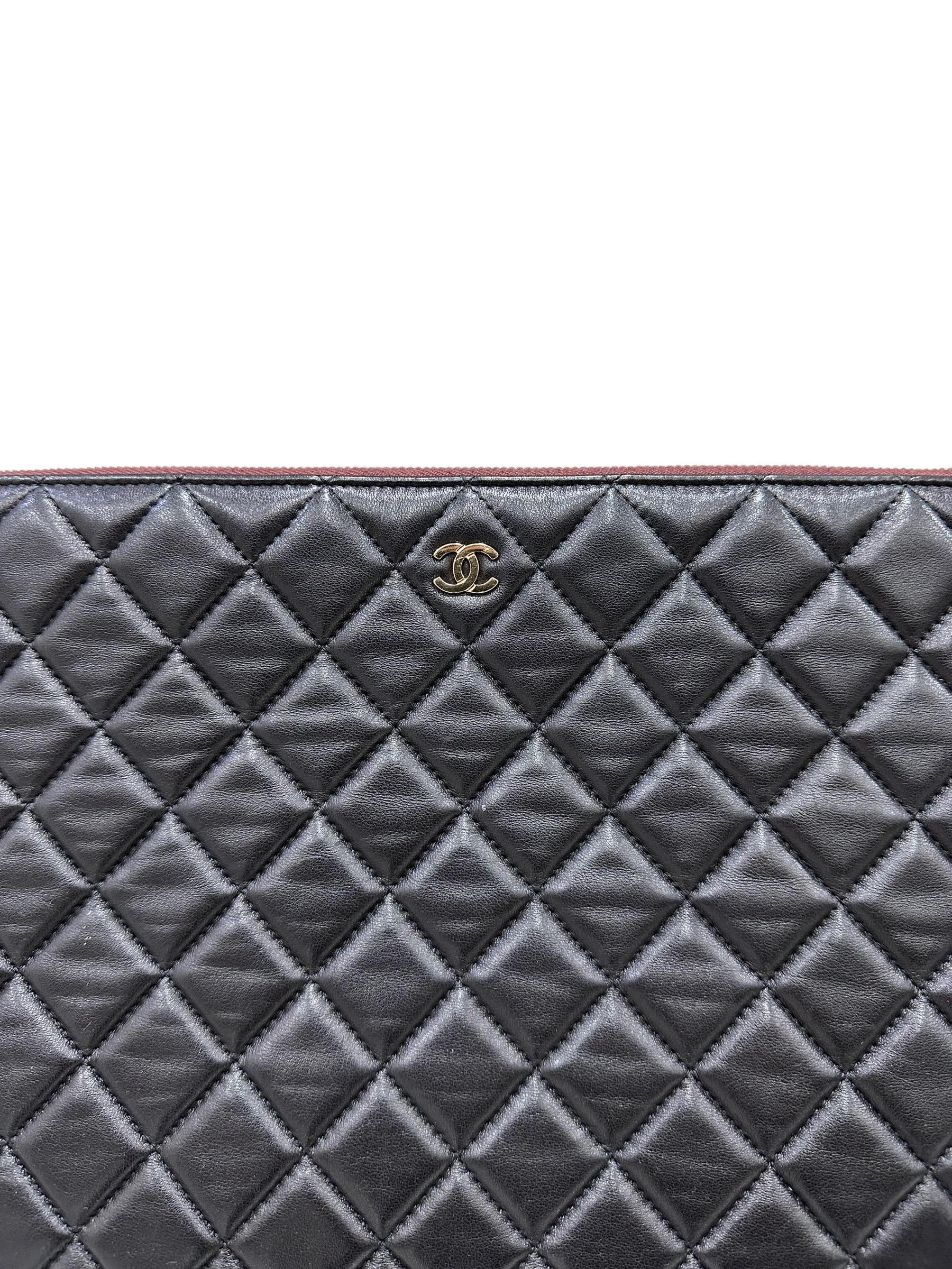 Clutch firmata Chanel, modello Timeless, realizzata in pelle liscia nera con hardware dorati. Dotata di una chiusura superiore con zip, internamente rivestita in tessuto trapuntato bordeaux, capiente per l’essenziale. Anno di produzione 2015/16, si