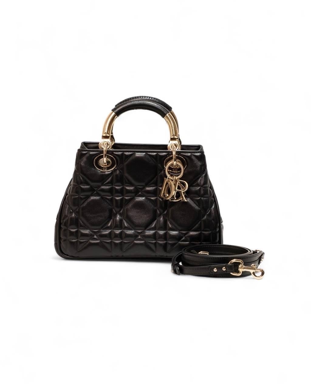 Borsa firmata Dior, linea Lady 95.22, misura Small, realizzata in pelle cannage nella colorazione nera con hardware dorati. Dotata di una chiusura interna ad incastro, internamente rivestita in tessuto scamosciato tono su tono, abbastanza capiente.