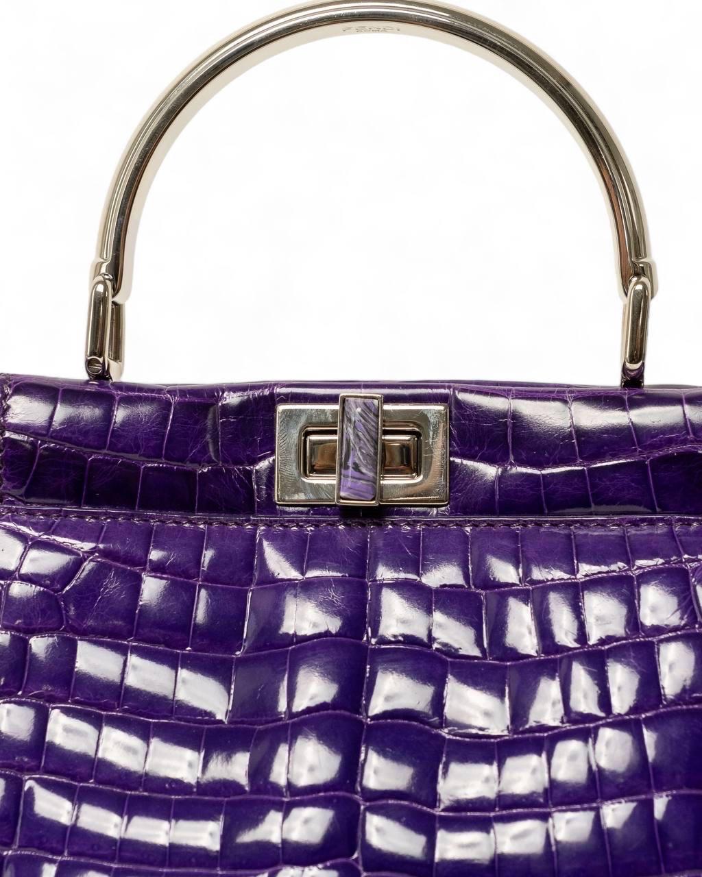 Borsa firmata Fendi, modello Peekaboo, misura mini, reaizzat in pelle  viola con hardware argentati. Dotata di una doppia chiusura a girello fronte retro, internamente rivestita in pelle liscia viola, capiente per l’essenziale. Munita di un manico