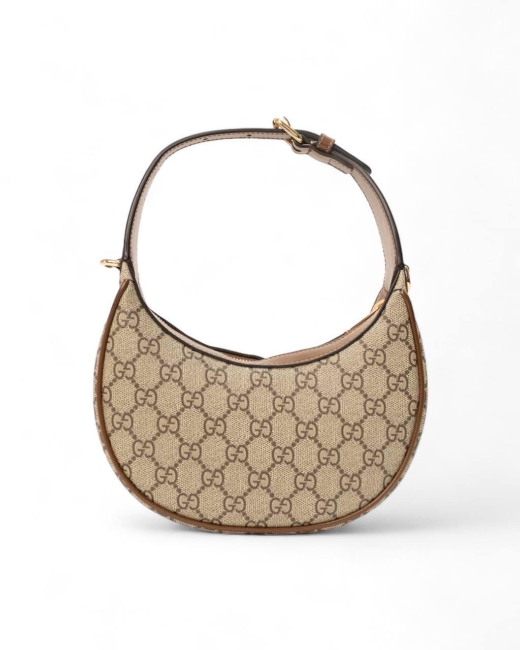 Borsa firmata Gucci, modello Mezzaluna, realizzata in tela beige nella classica fantasia GG Supreme con inserti in pelle marrone e hardware dorati. Dotata di una chiusura superiore a zip, internamente rivestita in tessuto scamosciato beige, capiente
