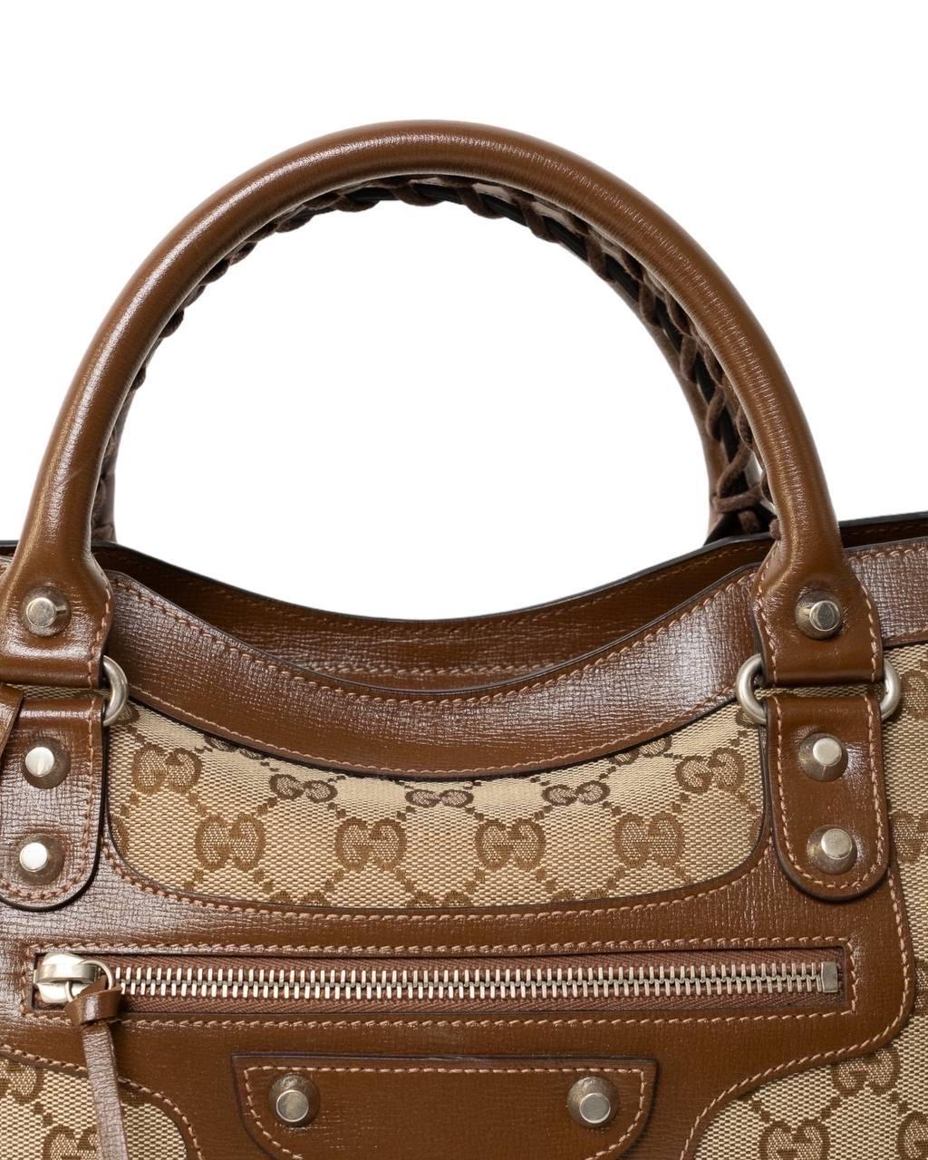 Borsa firmata Gucci x Balenciaga, modello city medium, per The Hacker Project, realizzata nella classica tela GG Supreme beige con inserti in pelle marrone e hardware argento. Dotata di una chiusura con zip, internamente rivestita in tela logata