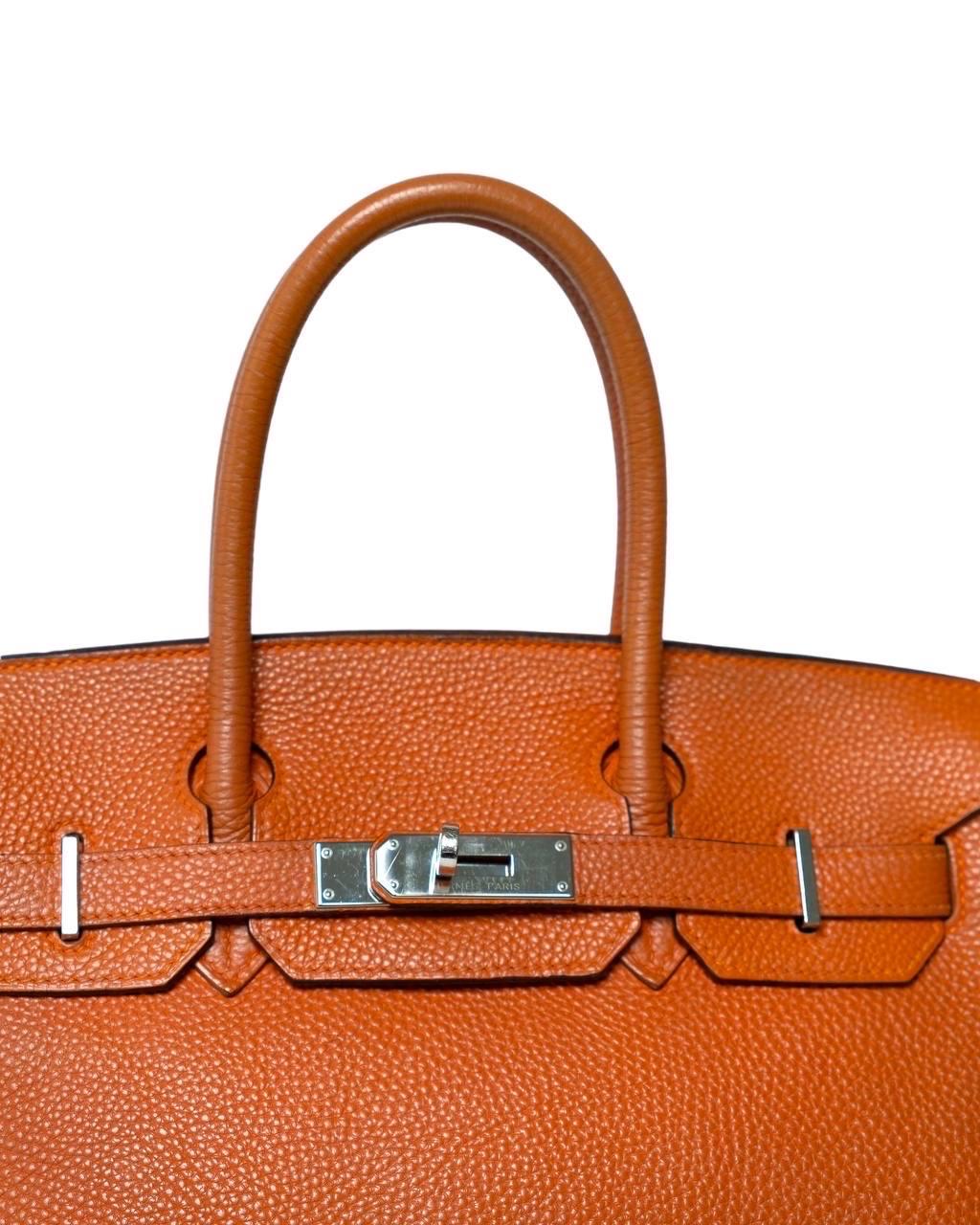 Borsa firmata Hermès, modello Birkin, misura 30, realizzata in pelle Togo, morbida al tatto con venature leggere, colore Potiron Orange, Dotata della classica patta ad incastro, con chiusura a fascia orizzontale. Internamente rivestita in pelle