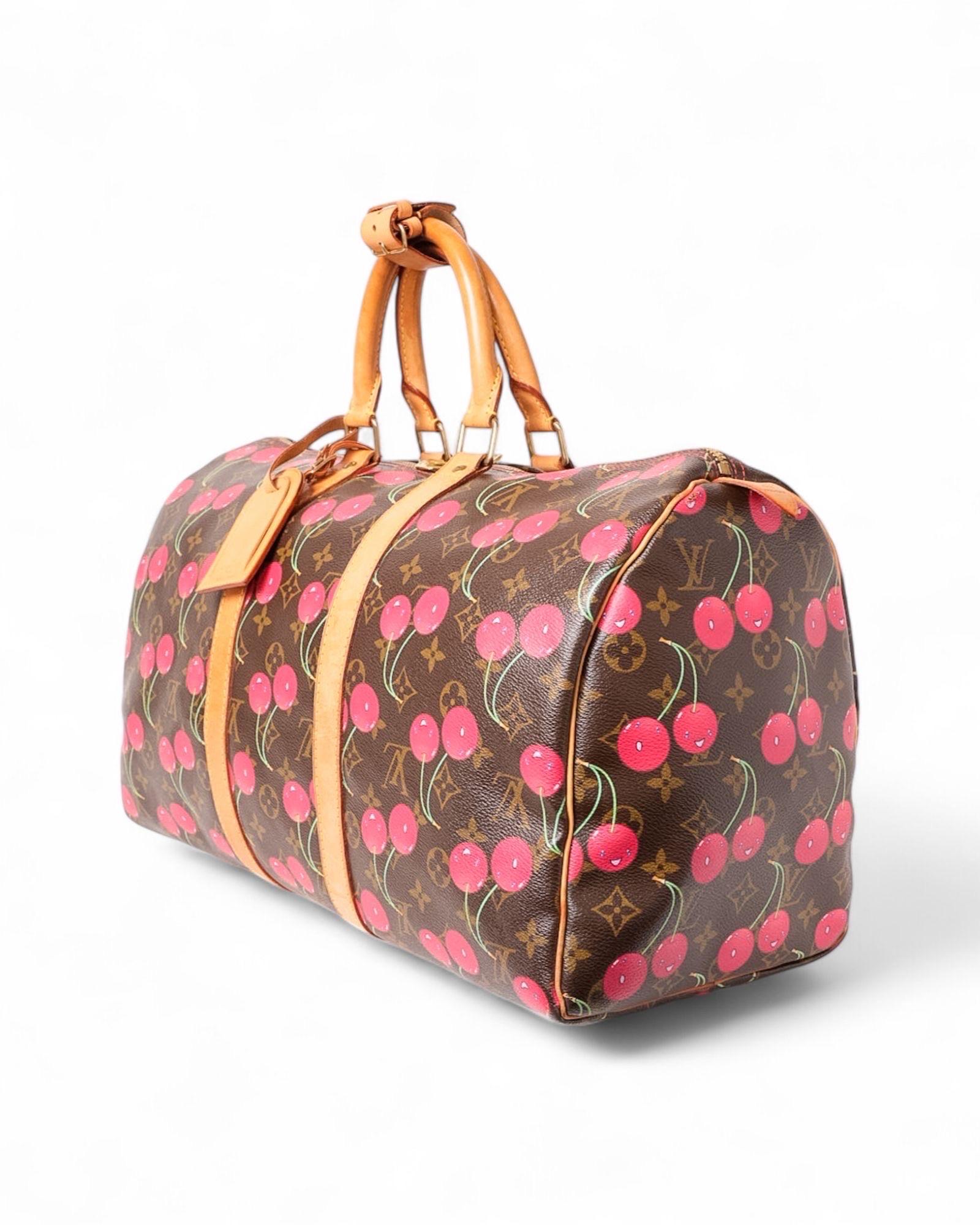 Borsa da viaggio firmato Louis Vuitton, modello Keepall, misura 45,edizione limitata realizzata in collaborazione con l’artista Takashi Murakami. Realizzato in tela marrone nella classica fantasia monogram, impreziosito da una fantasia Cerises e