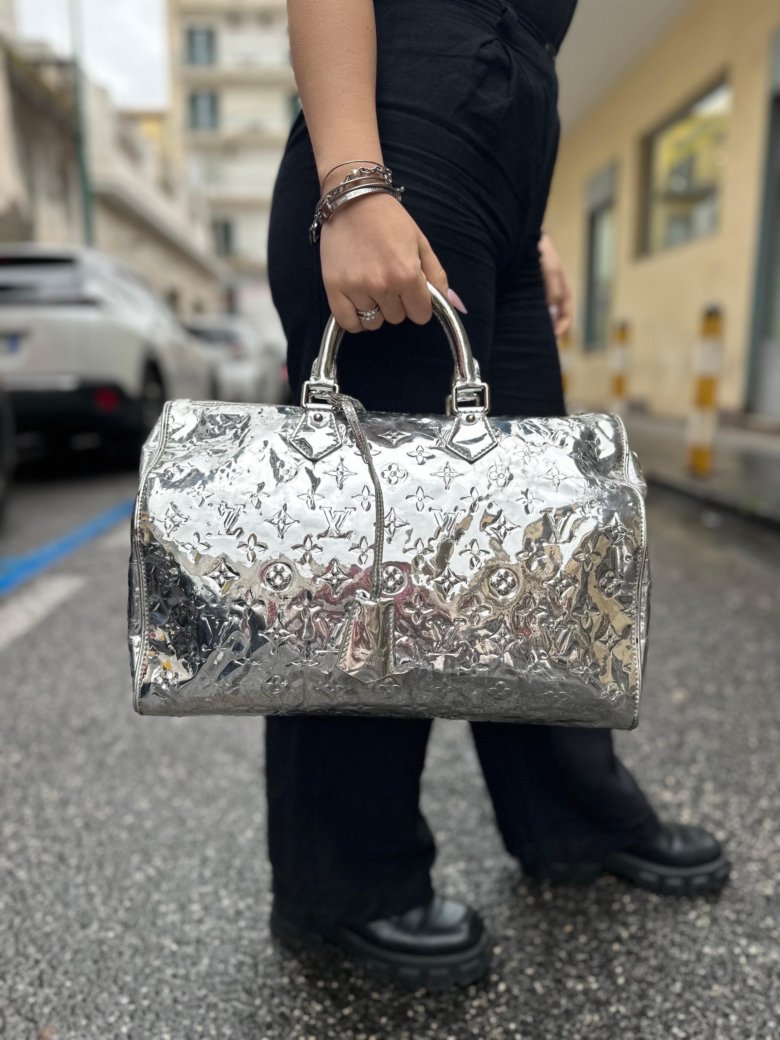 Borsa firmata Louis Vuitton, modello Speedy, in edizione limitata collezione anno 2008, misura 37, realizzata in pelle verniciata color argento e hardware argento. Dotata di una chiusura superiore con zip, internamente rivestita in tela grigia,
