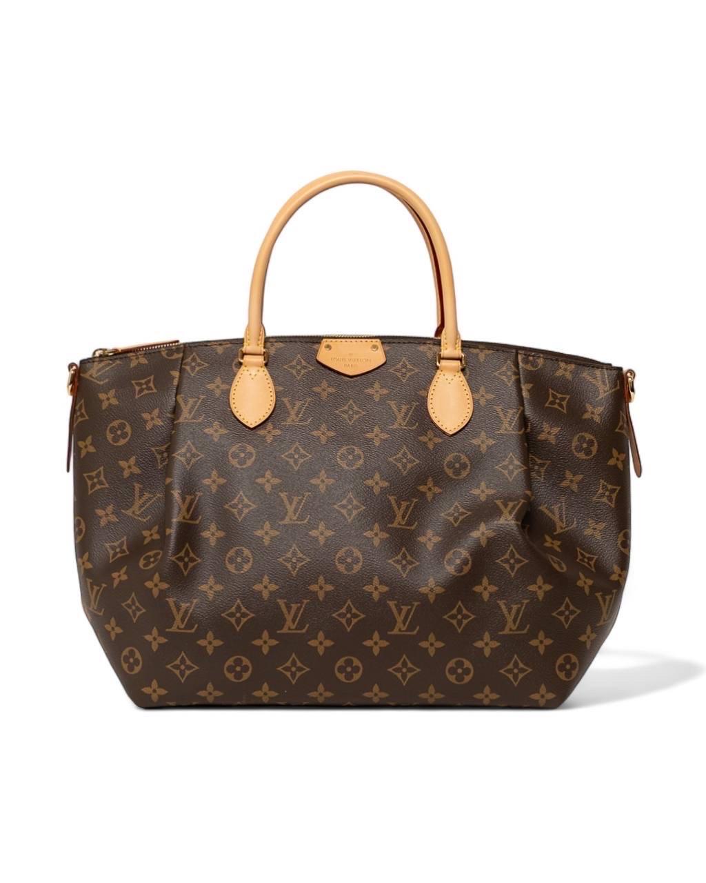 Borsa firmata Louis Vuitton, modello Turanne, misura GM, realizzata nella classica tela monogram con inserti in vacchetta e hardware dorati. Dotata di una chiusura superiore a zip, internamente rivestita in tela bordeaux con comode tasche,