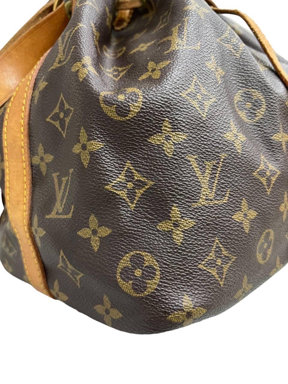 Louis Vuitton-Firmentasche, Modell Noè, Größe PM, aus klassischem Monogram-Tuch mit Einsätzen aus Vacchetta und verzierten Beschlägen. Sie ist mit einem oberen Abschluss mit Kragen versehen, der innen mit einem Marmorblock vernietet ist, der sehr