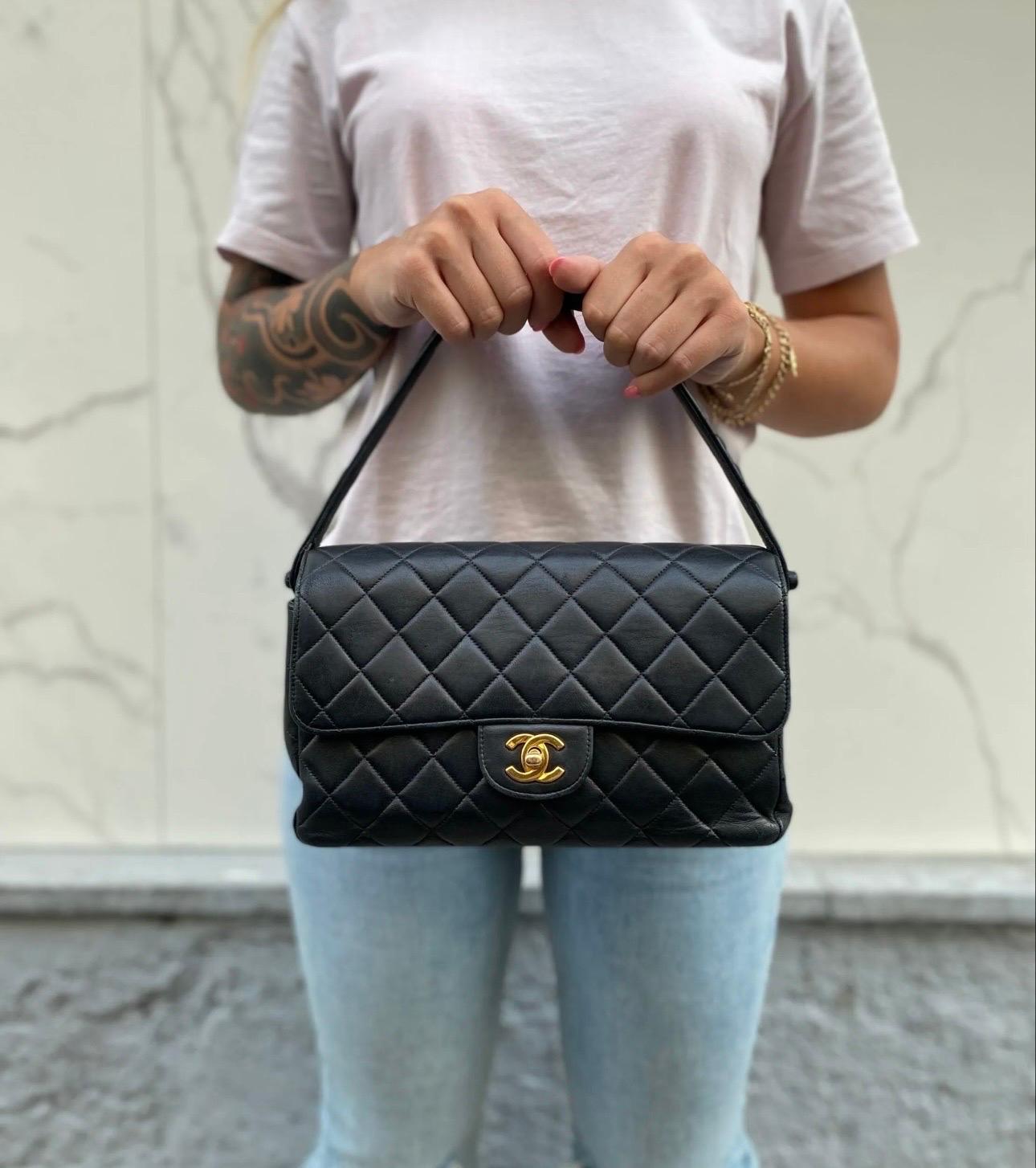 Borsa iconica di Chanel modello 2.55 Double Face in pelle trapuntata nera con hardware dorati. Predispone di due patte, una sulla parte anteriore e una sulla parte posteriore, entrambe munite di chiusura a girello ‘CC’. La borsa è suddivisa in due
