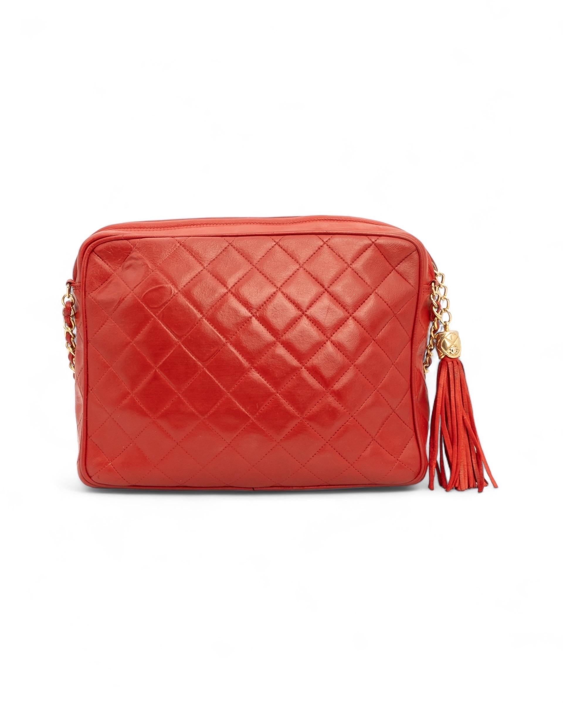 Borsa firmata Chanel, modello Camera Bag Vintage, realizzata in pelle rossa con hardware dorati. Con cierre superior de cremallera y charm de napa lateral,  internamente revestida en piel burdeos, con cómoda tapeta interna con cierre de cremallera,
