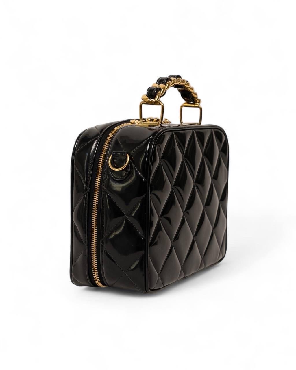 Borsa firmata Chanel, modello Cube Vintage, realizzata in pelle verniciata nera con hardware dorati. Dotata di una chiusura a zip semicircolare, internamente rivestita in pelle liscia tono su tono, capiente per l’essenziale. Munita di un manico