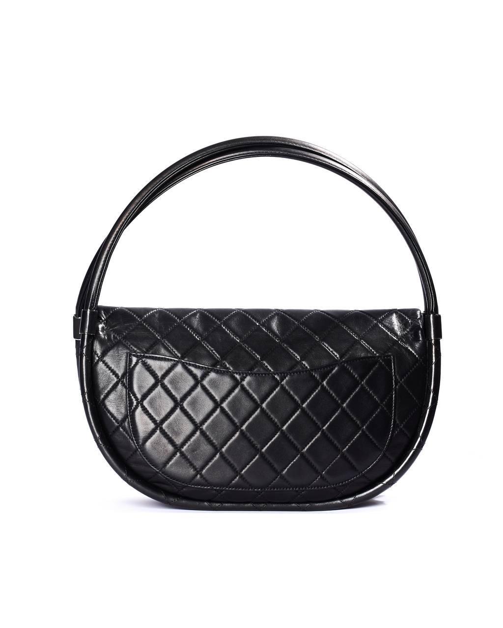 La borsa firmata Chanel, modello Hula Hop, è un’incantevole espressione di eleganza senza tempo. Realizzata in morbida pelle trapuntata di un raffinato nero, questa borsa è accentuata da hardware argentati che ne elevano il design, conferendole un