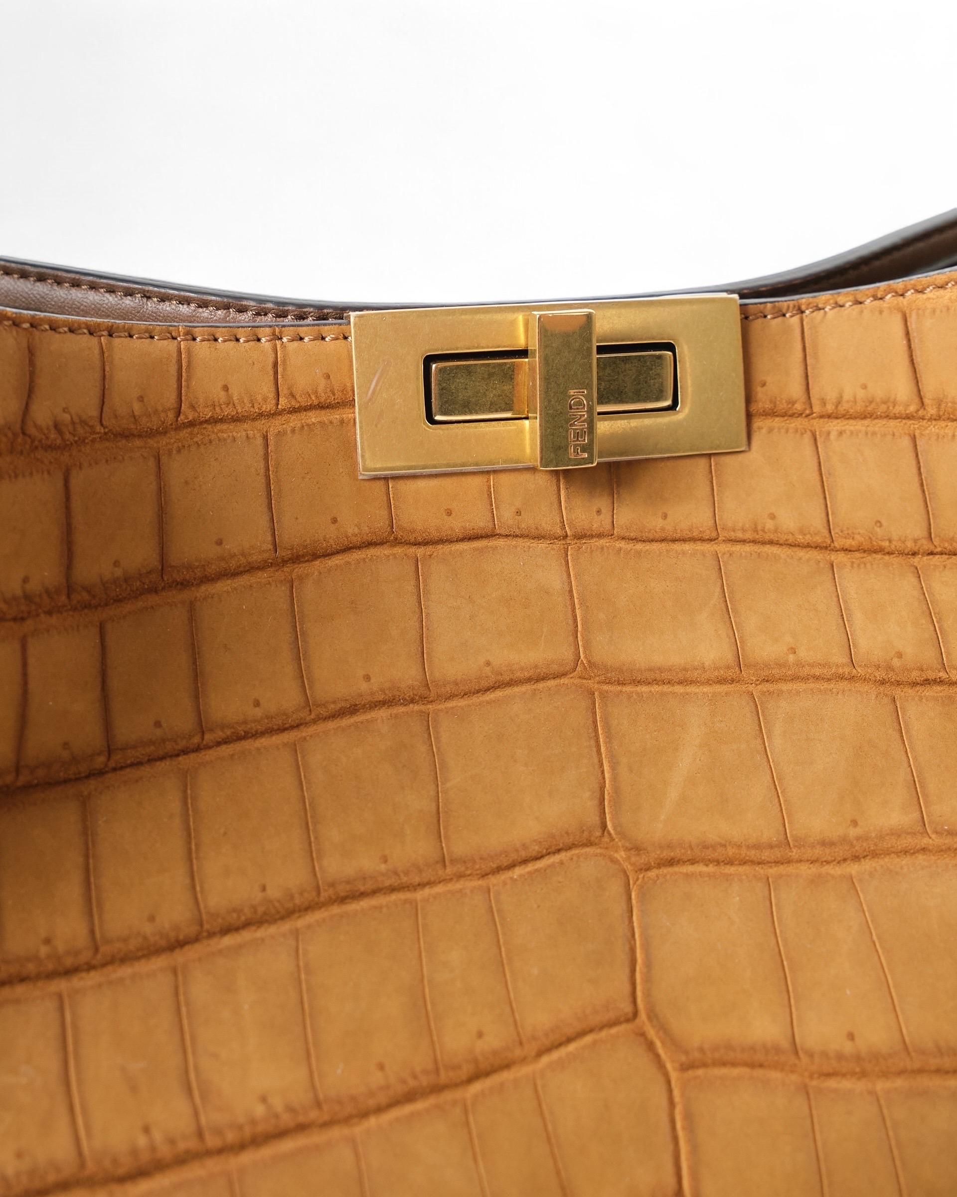 

Borsa Fendi, modello Peekaboo X-Lite, è realizzata in tessuto scamosciato effetto cocco di alta qualità, nella sofisticata colorazione marrone e ‘hardware dorato. Dotata di una chiusura centrale a girello consente un accesso sicuro e facile,