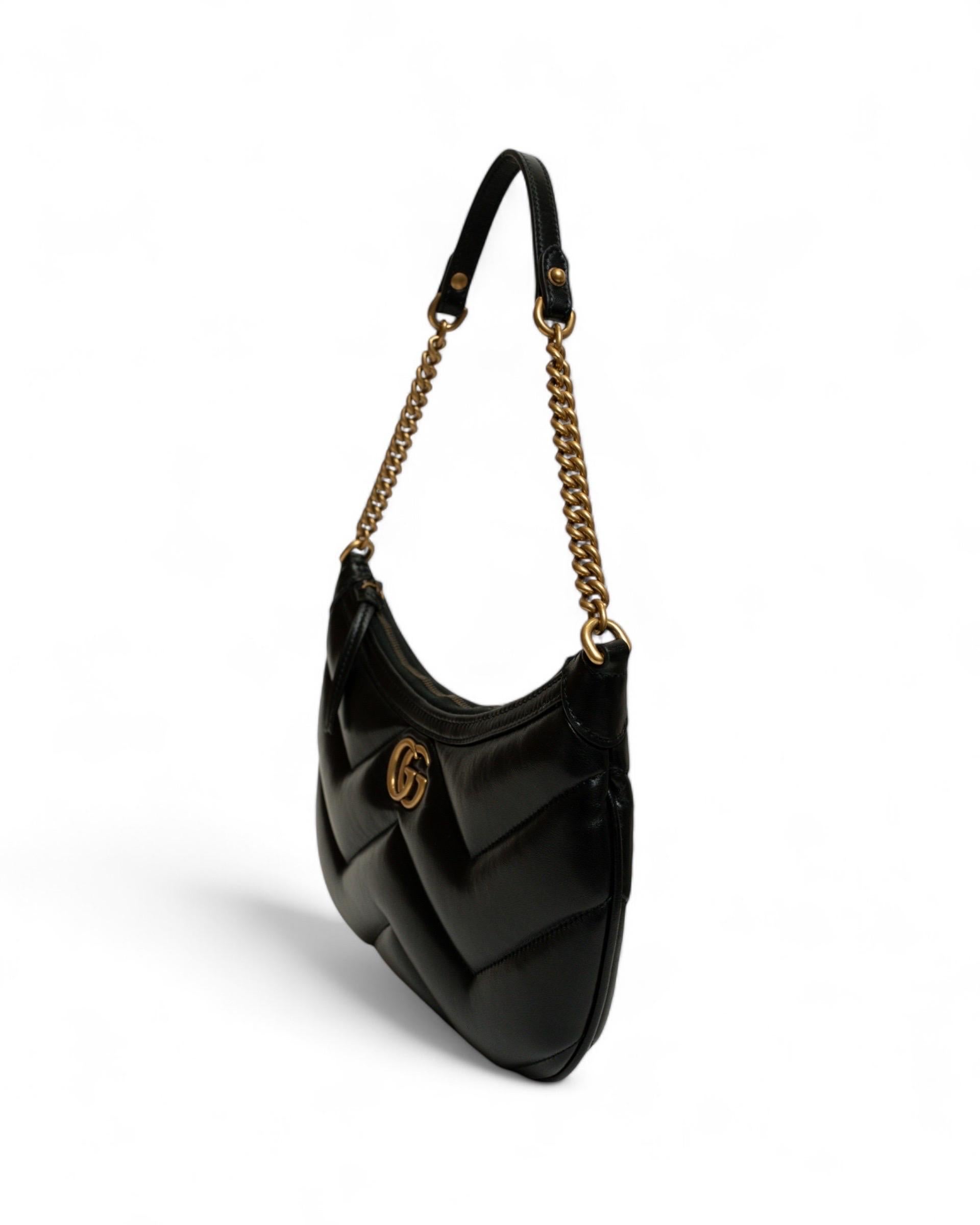 Borsa firmata Gucci, modello Hobo, linea Marmont, realizzata in pelle nera e hardware dorati. Sulla parte frontale presenta il logo del brand in rilievo. Munita di una chiusura con zip, internamente rivestita in camoscio di colore nero, capiente per