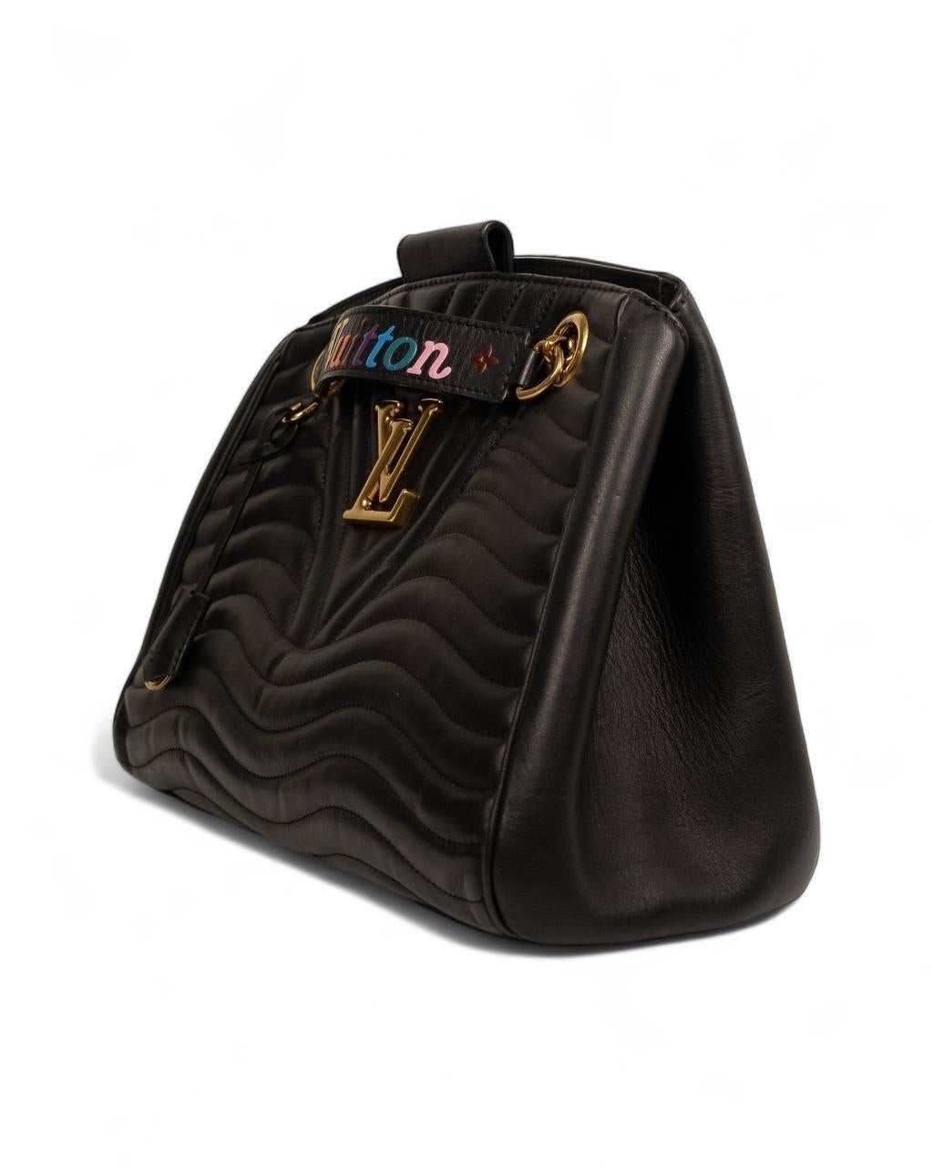 Borsa firmata Louis Vuitton, modello Shopper New Wave Chain, misura GM, realizzata in pelle nera con hardware dorati. Dotata di una chiusura superiore con patta calamitata, internamente rivestita in tessuto scamosciato tono su tono con comode