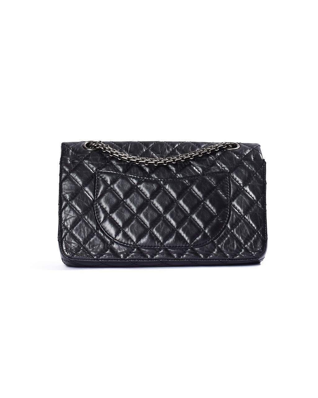 Borsa firmata Chanel, linea Reissue, modello 2.55 Lucky, in Edizione Limitata, rende omaggio a Parigi, con charm che raffigurano simboli iconici della città. Realizzata in pregiata pelle nera con hardware argentati, questa borsa è caratterizzata da