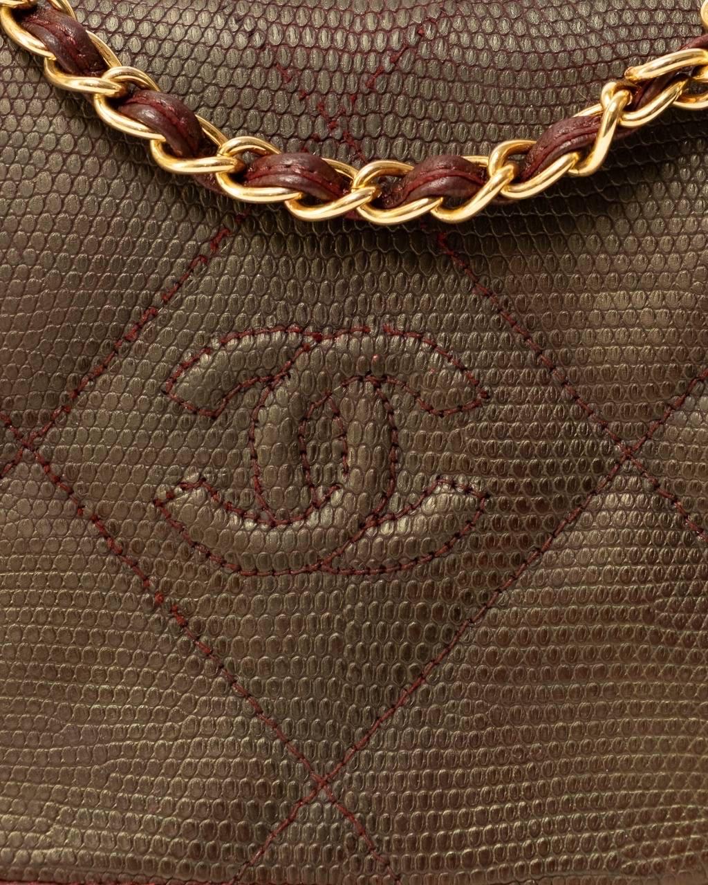 Borsa firmata Chanel, modello vintage, realizzata in pelle  bordeaux con hardware dorati. Dotata di una patta frontale con chiusura a bottone, internamente rivestita in pelle liscia bordeaux con tasca  interna con chiusura a zip. Munita di una