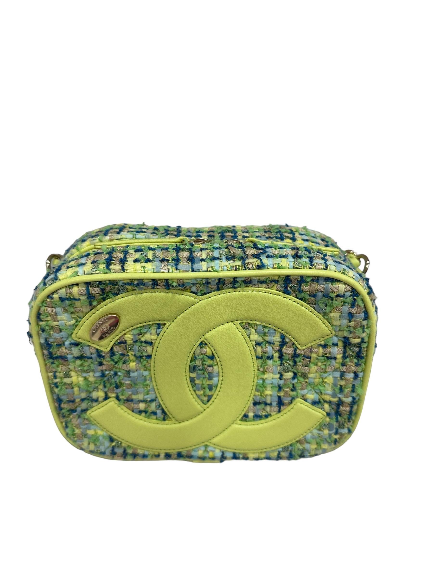 Borsa firmata Chanel, mdoello Camera Bag, realizzat ain tessuto tweed con inserti in pelle color lime e hardware dorati. Dotata di una chisuura superiore con zip, internamente rivestita in tela blu, capiente per l’essenziale. Munita di una tracolla
