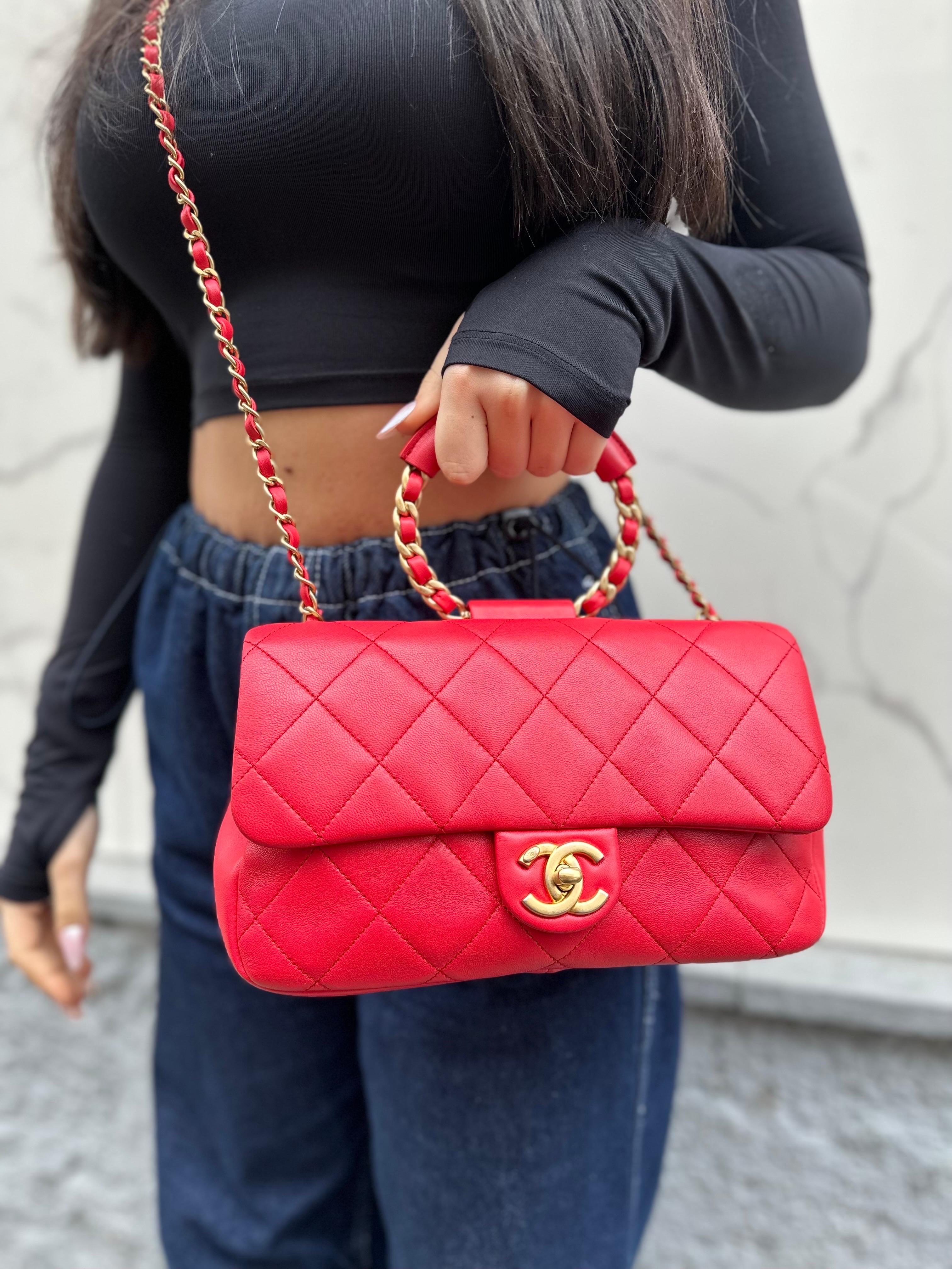 Borsa firmata Chanel, modello Circle Handle, realizzata in pelle liscia rossa con hardware dorati. Dotata di una patta frontale con chiusura a girello con logo 