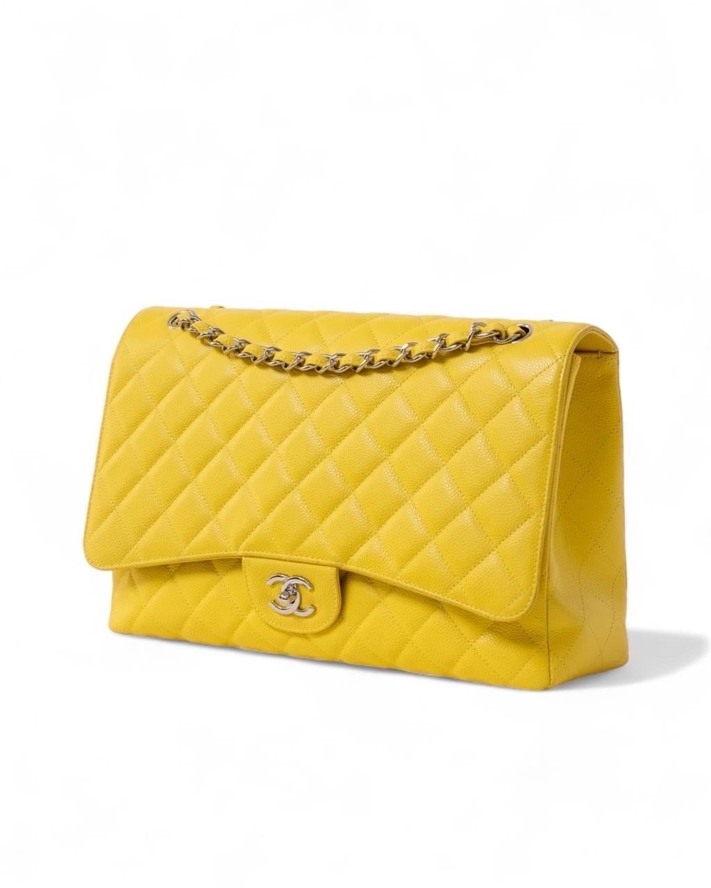 Borsa firmata Chanel, modello Timeless, misura Maxi Jumbo, realizzata in pelle trapuntata caviar nella colorazione gialla con hardware argentati. Dotata di una patta frontale con chiusura a girello con classico logo “CC”. Internamente rivestita in
