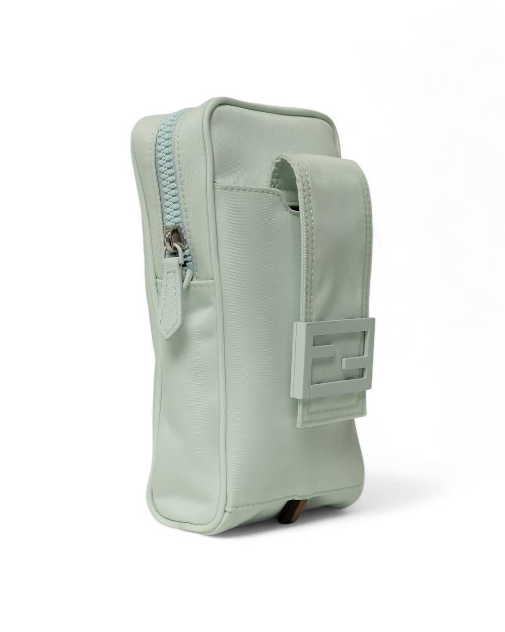 Portacellulare firmato Fendi, realizzato in nylon nella colorazione azzurro con hardware argentati. Dotato di una chiusura superiore a zip, internamente rivestito in tessuto nero, capiente per l’essenziale. Munito di una tracolla rimovibile e