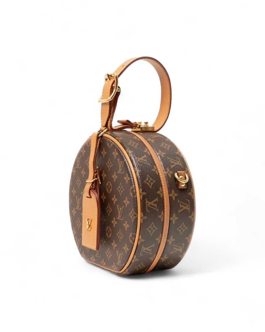 Borsa firmata Louis Vuitton, modello Petit Boite Chapeau, misura BB, realizzata nella classica tela monogram con inserti in vacchetta e hardware dorati. Dotata di una chiusura superiore ad incastro, internamente rivestita in pelle di agnello beige,
