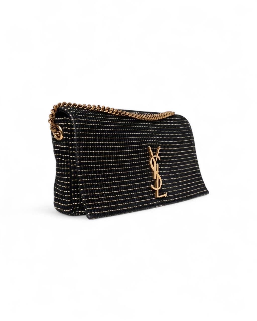 Borsa firmata Saint Laurent, linea Kate 99, modello Shoulder, realizzata in velluto nero con rifiniture in lurex oro e hardware dorati. Dotata di una patta con chiusura a bottone calamitato, internamente rivestita in tessuto nero con comoda tasca,