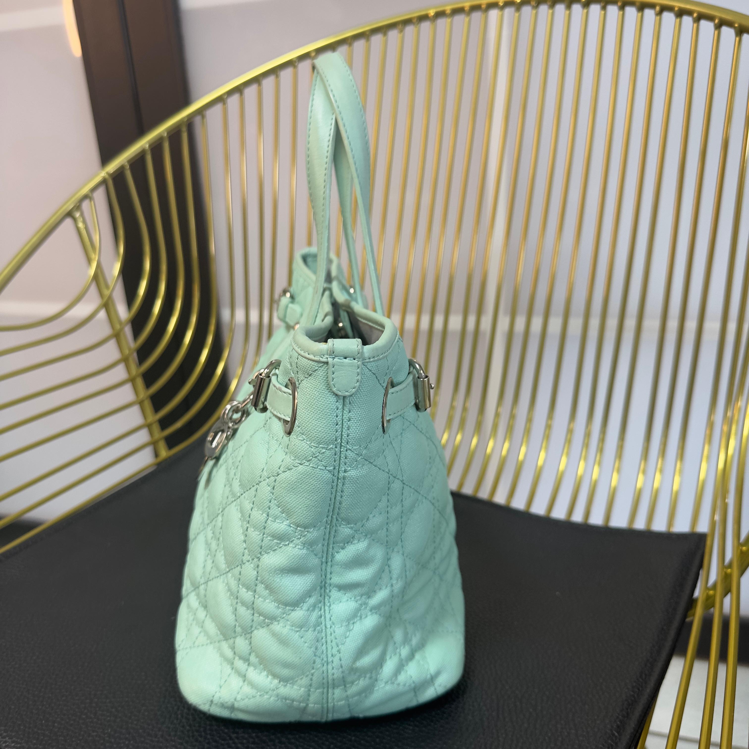 Diese raffinierte und leuchtende Tasche von Dior ist ein Schmuckstück für Sammler der 2000er Jahre. Sie ist aus gestepptem Canvas in Petrol mit Ton-in-Ton-Lederdetails gefertigt und verfügt über ikonische metallische 