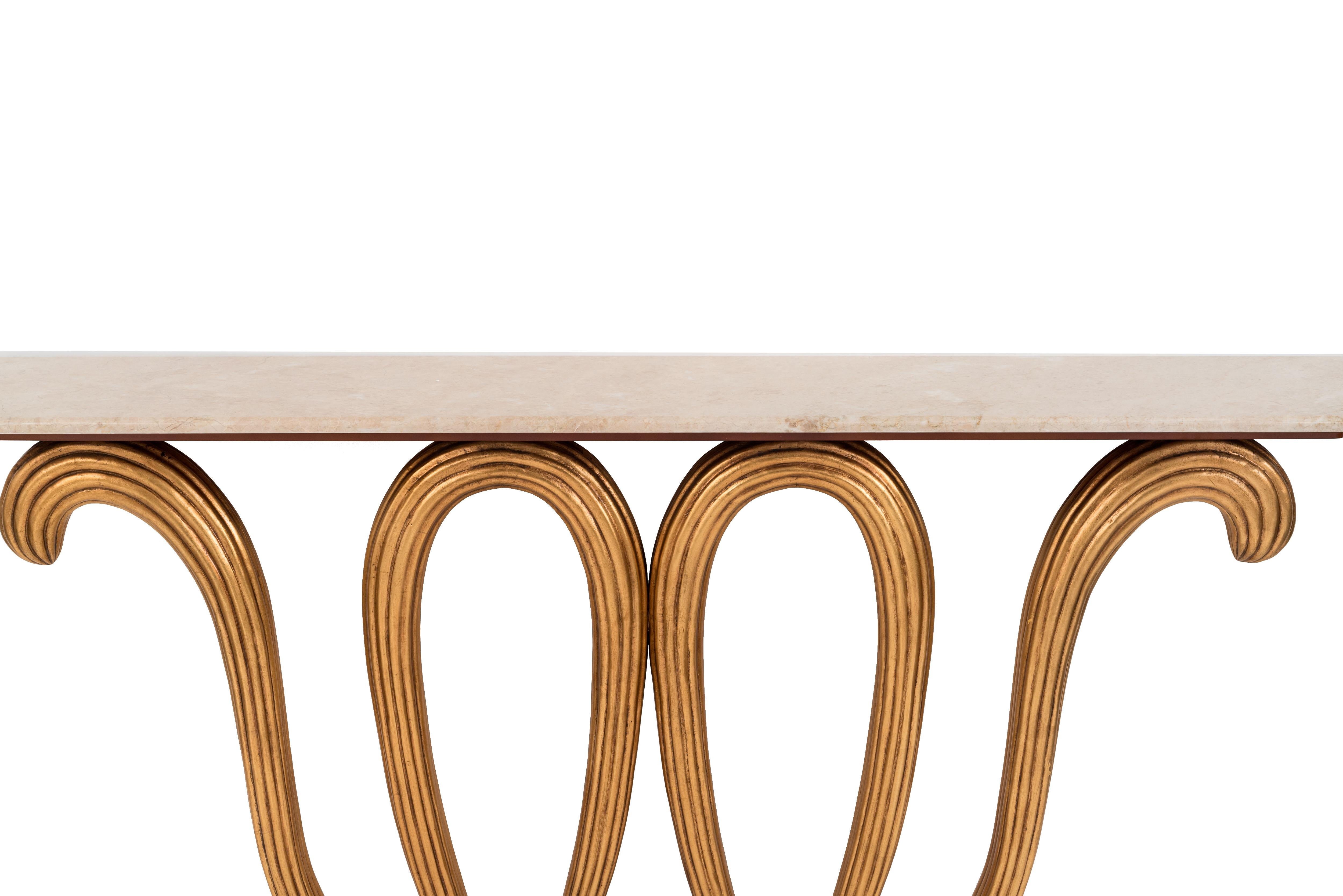Inspired by the designer Borsani, the base is a carved and reeded series of loops, which support the Crema Marfil marble top. The console table is not freestanding and must be secured to the wall. Not freestanding, must be bolted to wall. (John