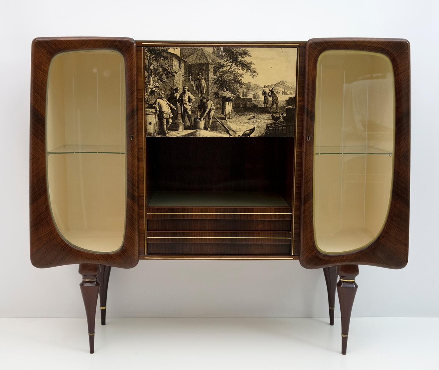 Modern Italian mid-century display cabinet or bar characterized by two splendid wooden doors protruding from the structure, the central part consists of a flap, on which an eighteenth-century style image is printed, a compartment with a ivory glass