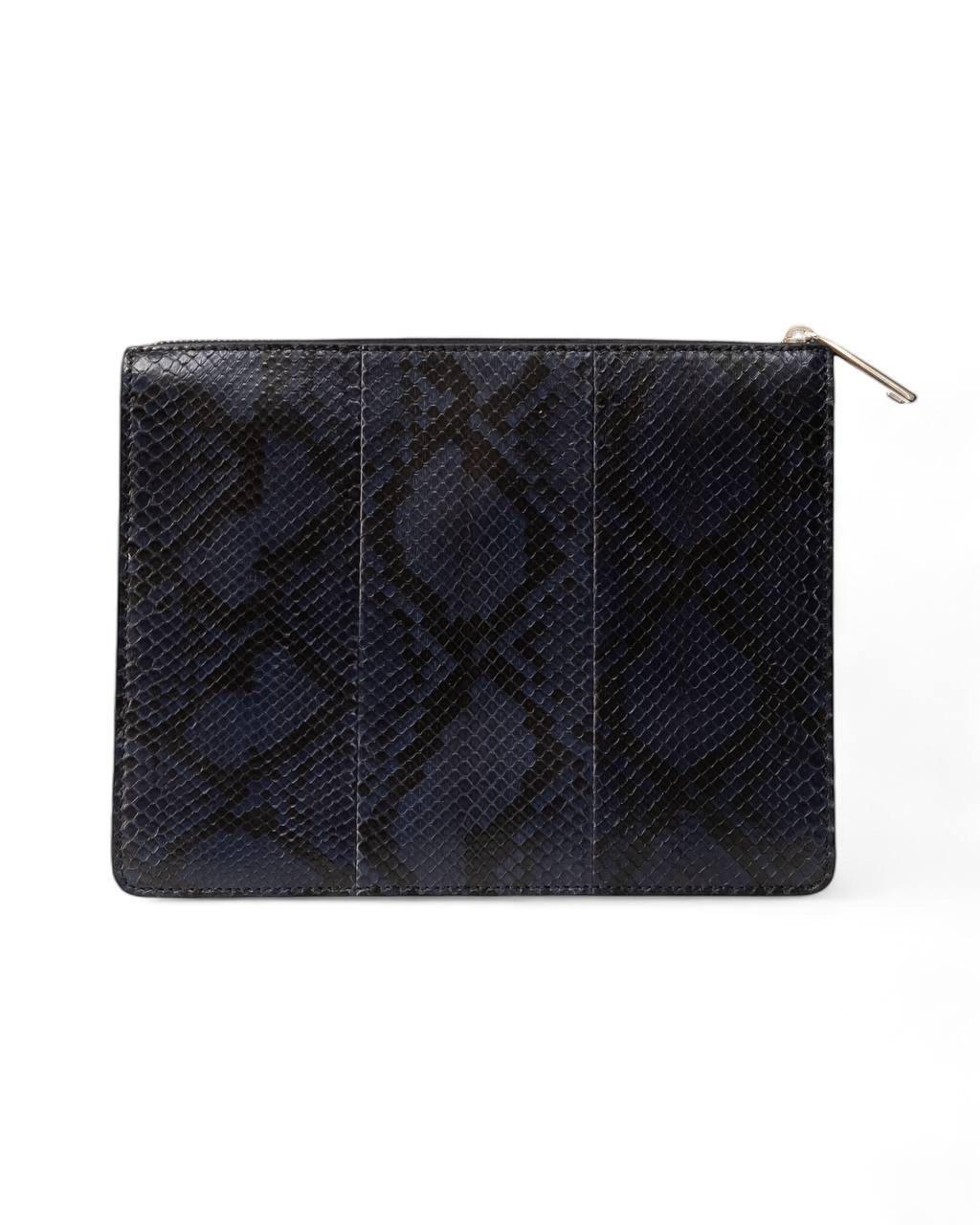 Pochette firmata Fendi, realizzata in pelle blu e nera con hardware argentati. Dotata di una chiusura superiore a zip, internamente rivestita in tessuto scamosciato blu con molteplici tasche capiente per l'essenziale. L'articolo si presenta in