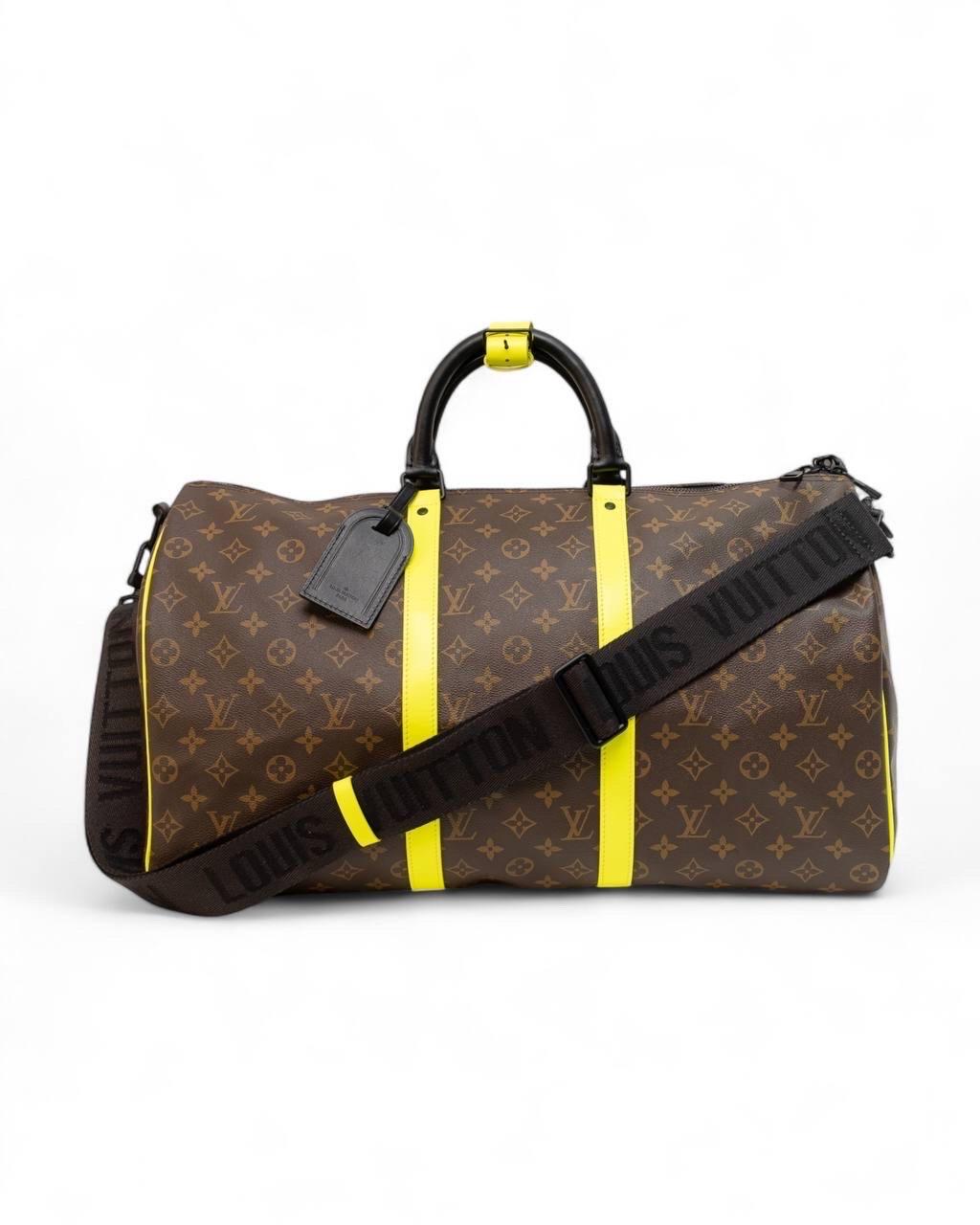 Borsone firmato Louis Vuitton, modello Keepall Bandouliére, misura 50, realizzato in tela nella classica fantasia monogram con inserti in pelle giallo fluo e nero. Dotato di una chiusura superiore a zip a doppio cursore, internamente rivestito in
