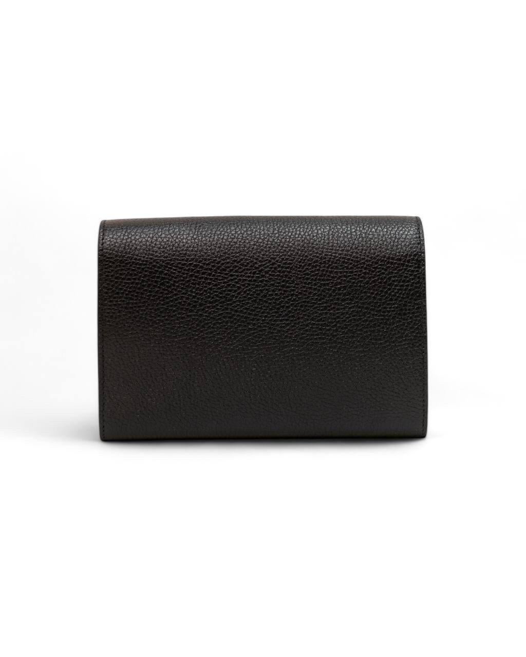 Borsa firmata Gucci, modello Pochette, realizzata in pelle granulata nera con hardware dorati. Dotata di una patta frontale con chiusura a bottone, internamente rivesitata in pelle e tela tono su tono con diverse tasche. Munita di una tracolla