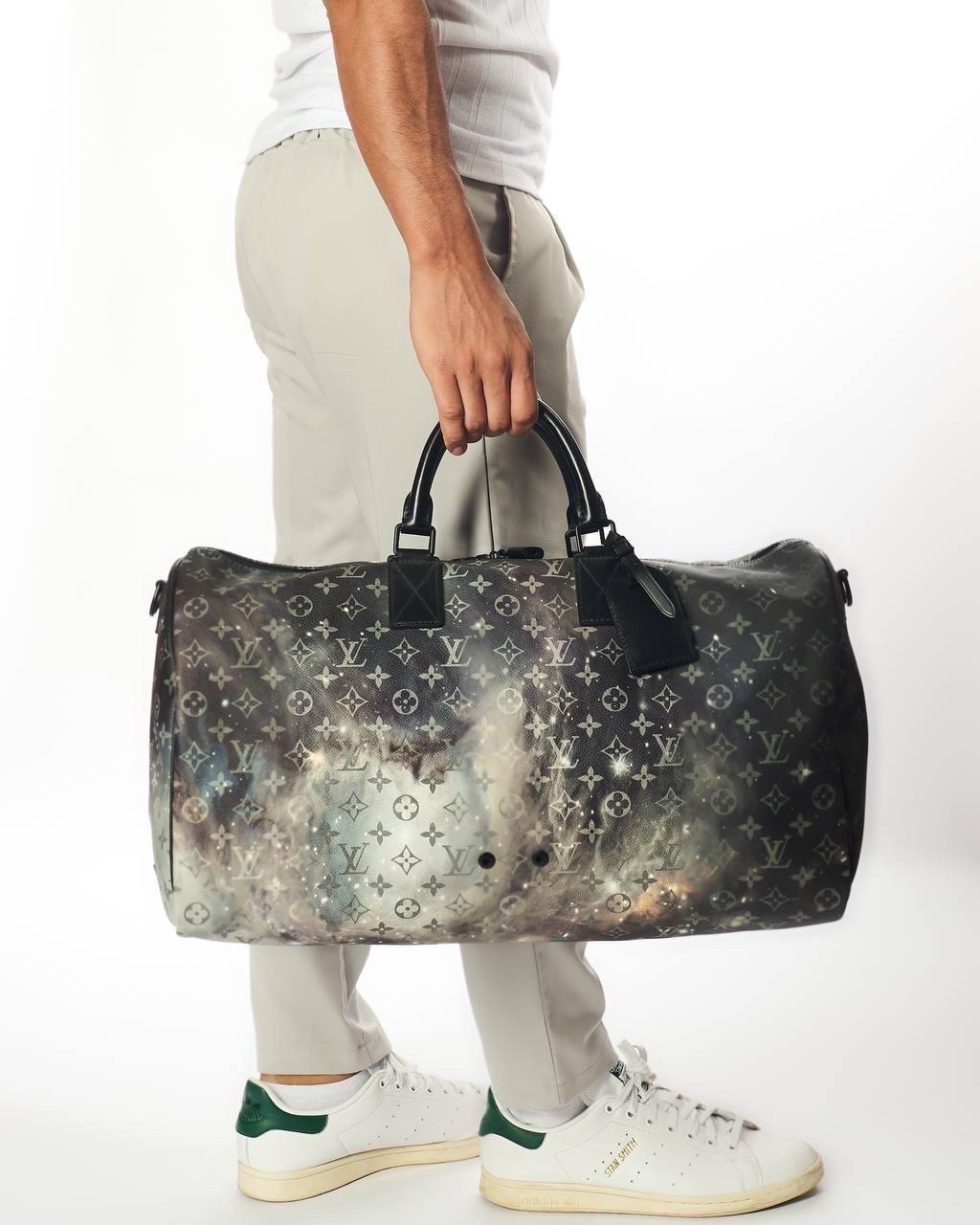 Borsone da viaggio firmato Louis Vuitton, modello Keepall, misura 50, in edizione limitata, collezione Galaxy. Realizzato in tela Monogram Black Multicolor con hardware neri. Dotato di un’apertura superiore con chiusura a zip e completo di un
