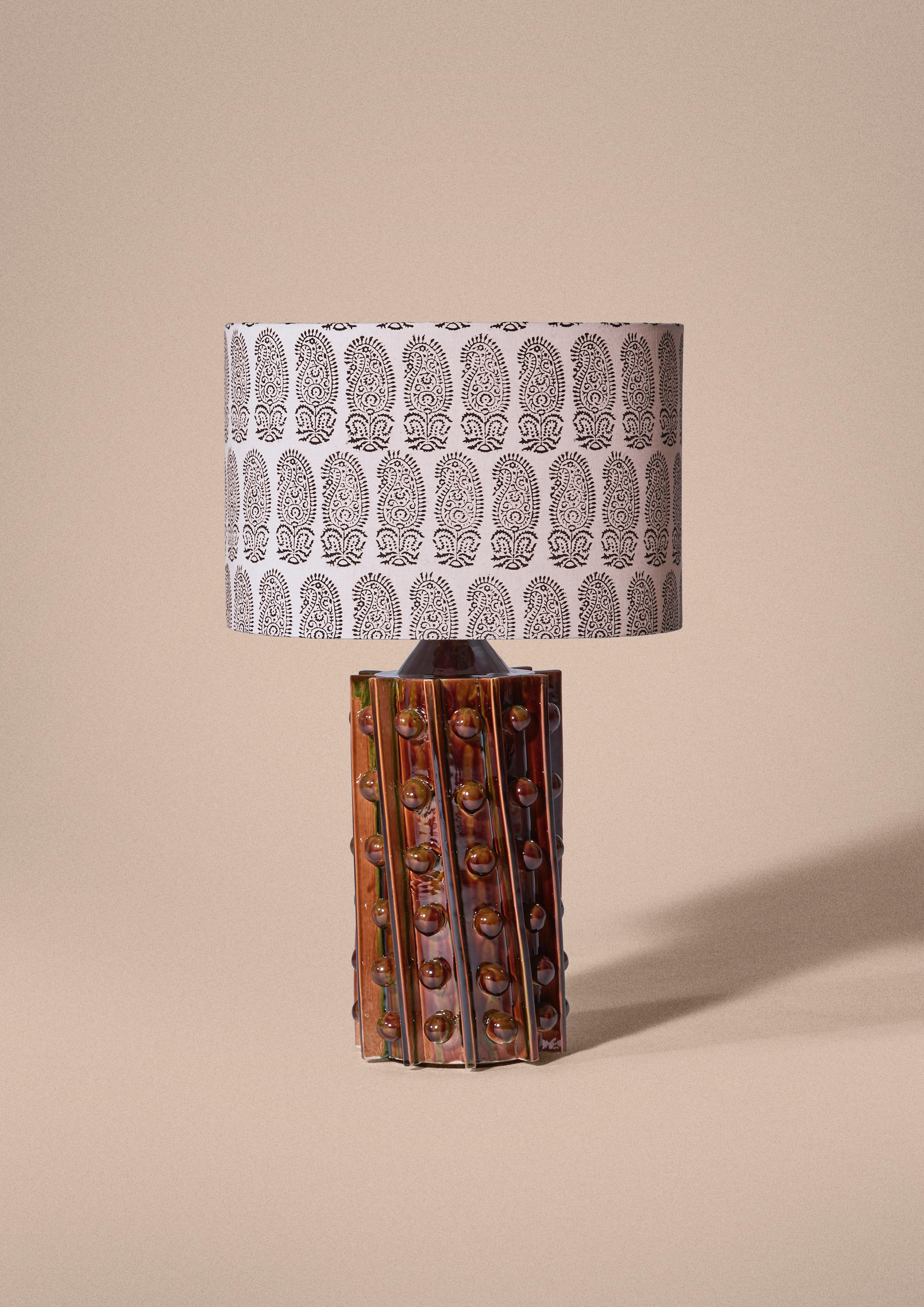 Ceramic foot with geometric relief produced by the Jean Roger workshop in Paris. Available in different colors for the foot, and different fabrics for the oval lampshade. All is crafted in Paris.