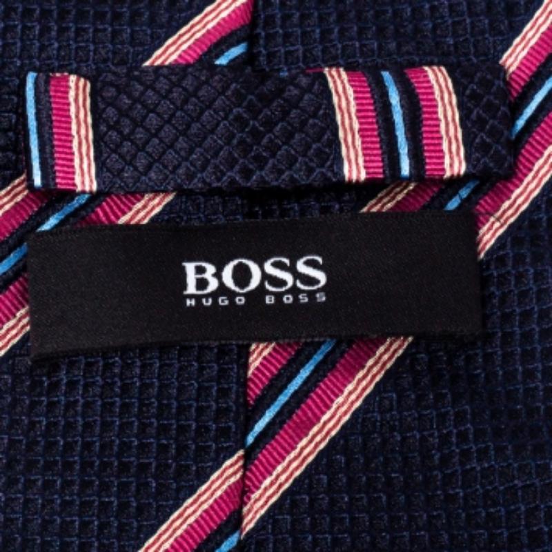 This Boss By Hugo Boss tie is a perfect formal accessory that has a sharp and modern appeal. Made from 100% silk, it features blue and pink shades, a penny keeper strap, and the brand label neatly stitched at the back. It is sure to add oodles of