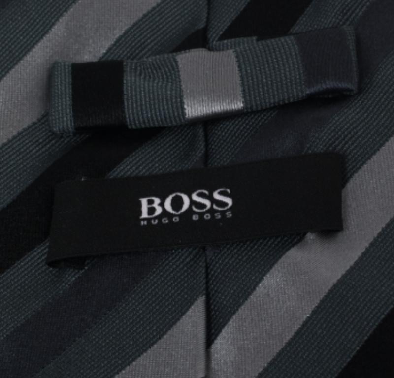 This Boss By Hugo tie is a perfect formal accessory that has a sharp and modern appeal. Made from silk, it features a dark grey shade, diagonal stripes, and the brand label neatly stitched at the back. It is sure to add oodles of style to your