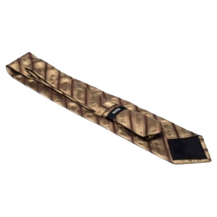 This Boss By Hugo Boss tie lends a sophisticated look to your ensemble with its modern appeal. The gold diagonal striped pattern adorned all over this tie looks tasteful.