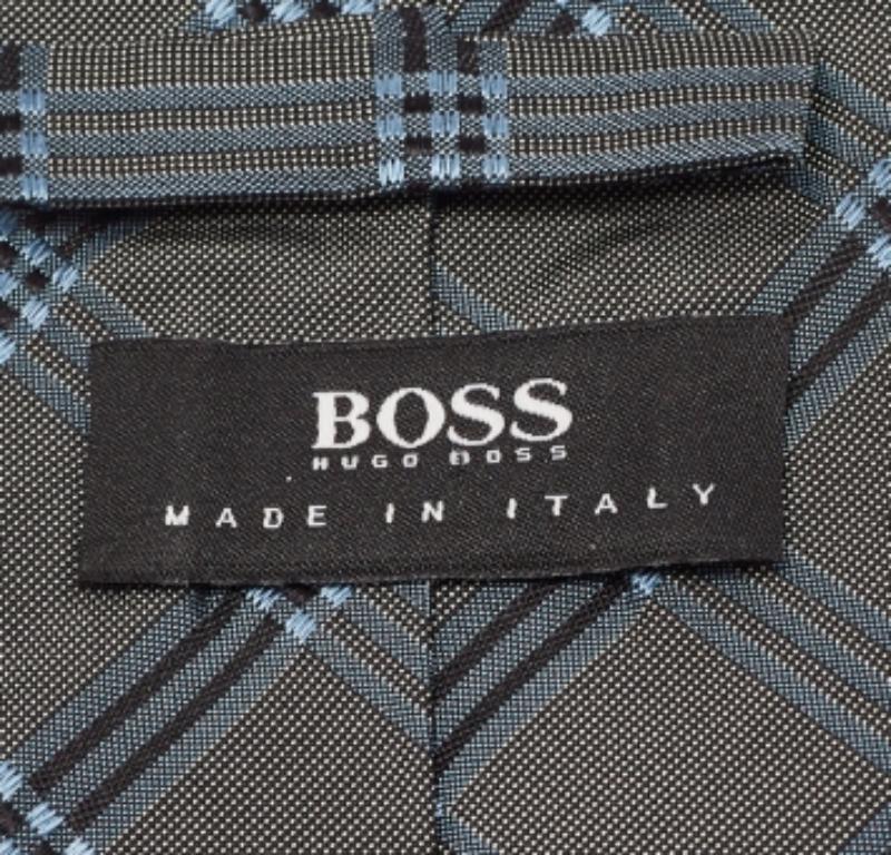 Realizzata in seta, questa cravatta da uomo Boss By Hugo Boss grigio/blu ha una stampa a quadri su tutta la superficie. Questo accessorio finemente confezionato aggiungerà un tocco di charme.