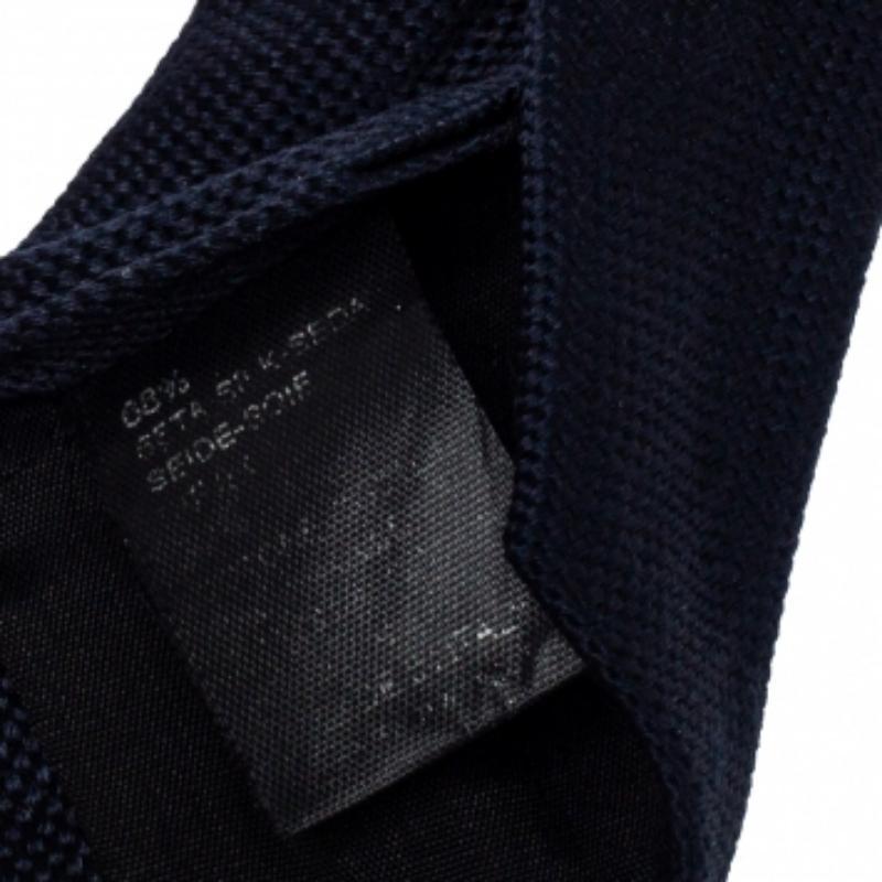 This Boss By Hugo Boss tie is a perfect formal accessory that has a sharp and modern appeal. Made from a cotton-silk blend, it features a navy blue hue, a penny keeper strap, and the brand label neatly stitched at the back. It is sure to add oodles