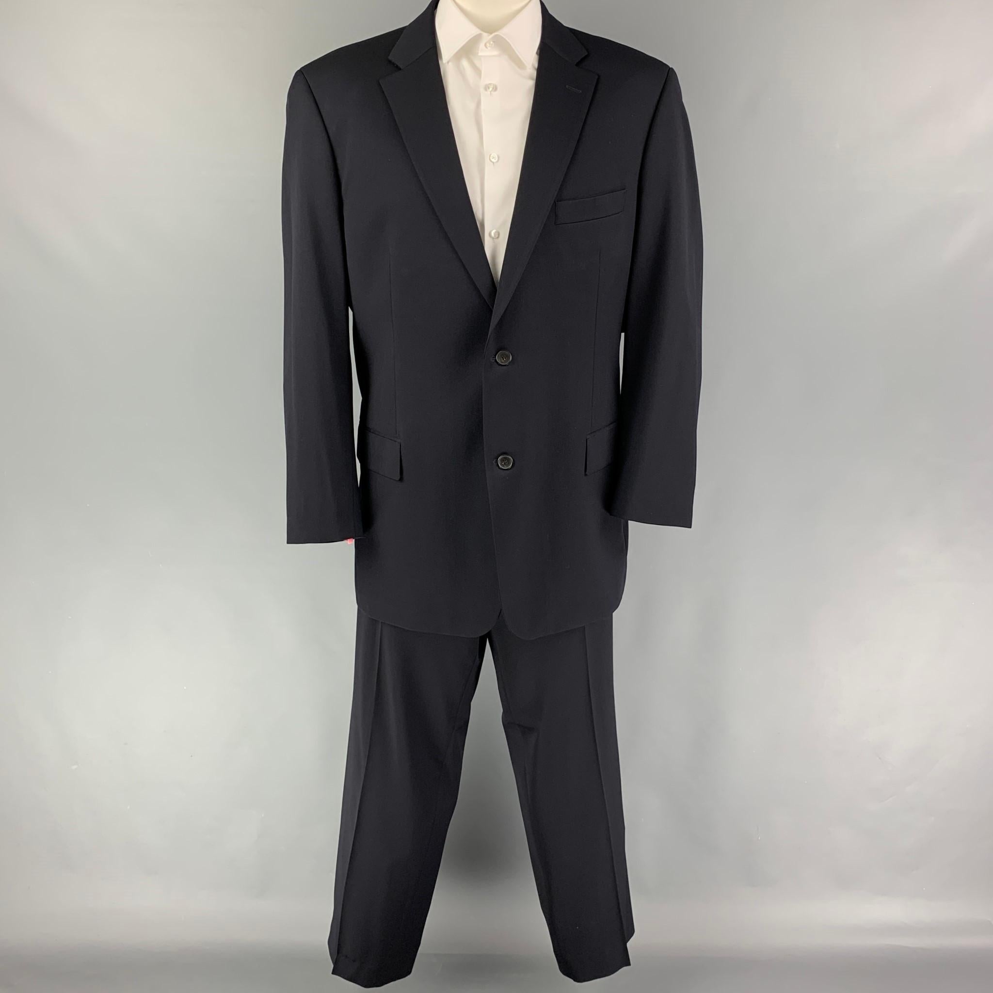 BOSS by HUGO BOSS suit comes in a navy virgin wool with a full liner and includes a single breasted, double button sport coat with a notch lapel and matching flat front trousers.

Very Good Pre-Owned Condition.
Marked: 48